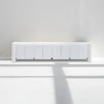 Load image into Gallery viewer, White TV unit showcased in a vibrant living room, emphasizing its contemporary appeal.