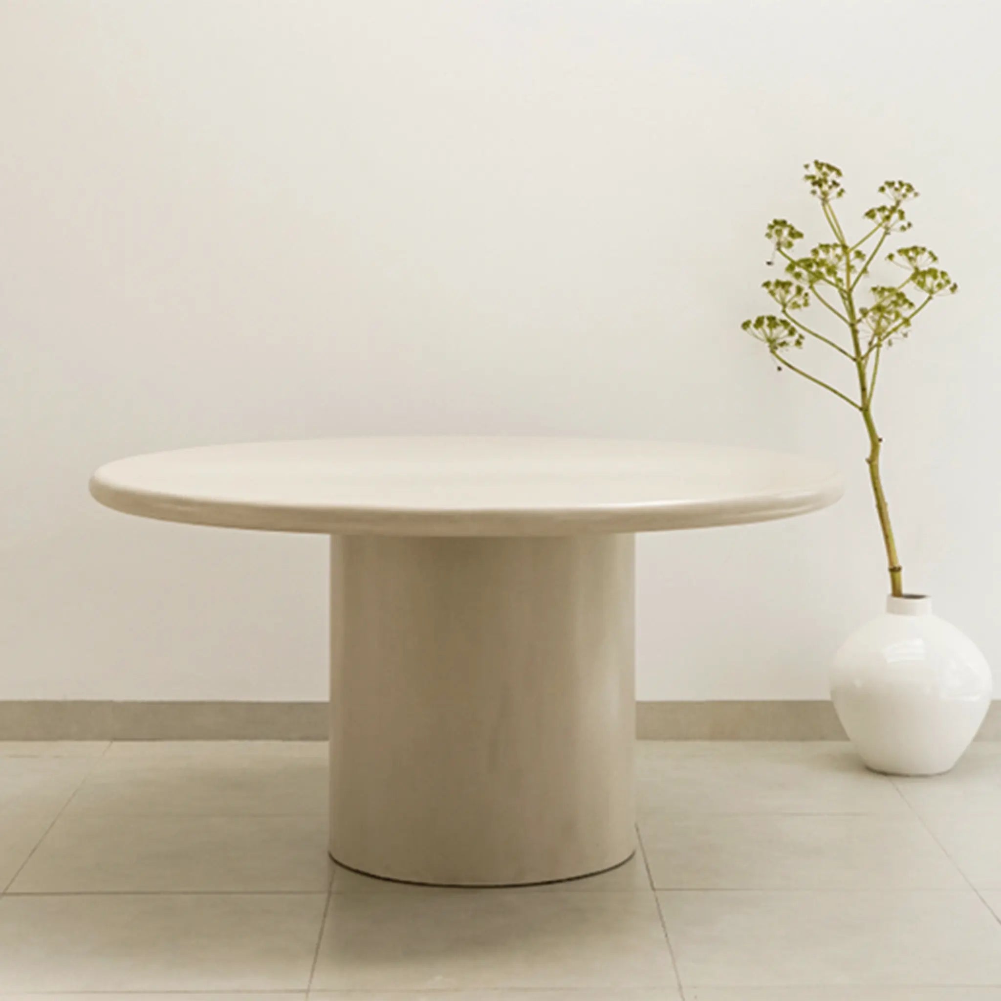 The Marx Microplaster round dining table styled in a contemporary dining room, offering both elegance and function.