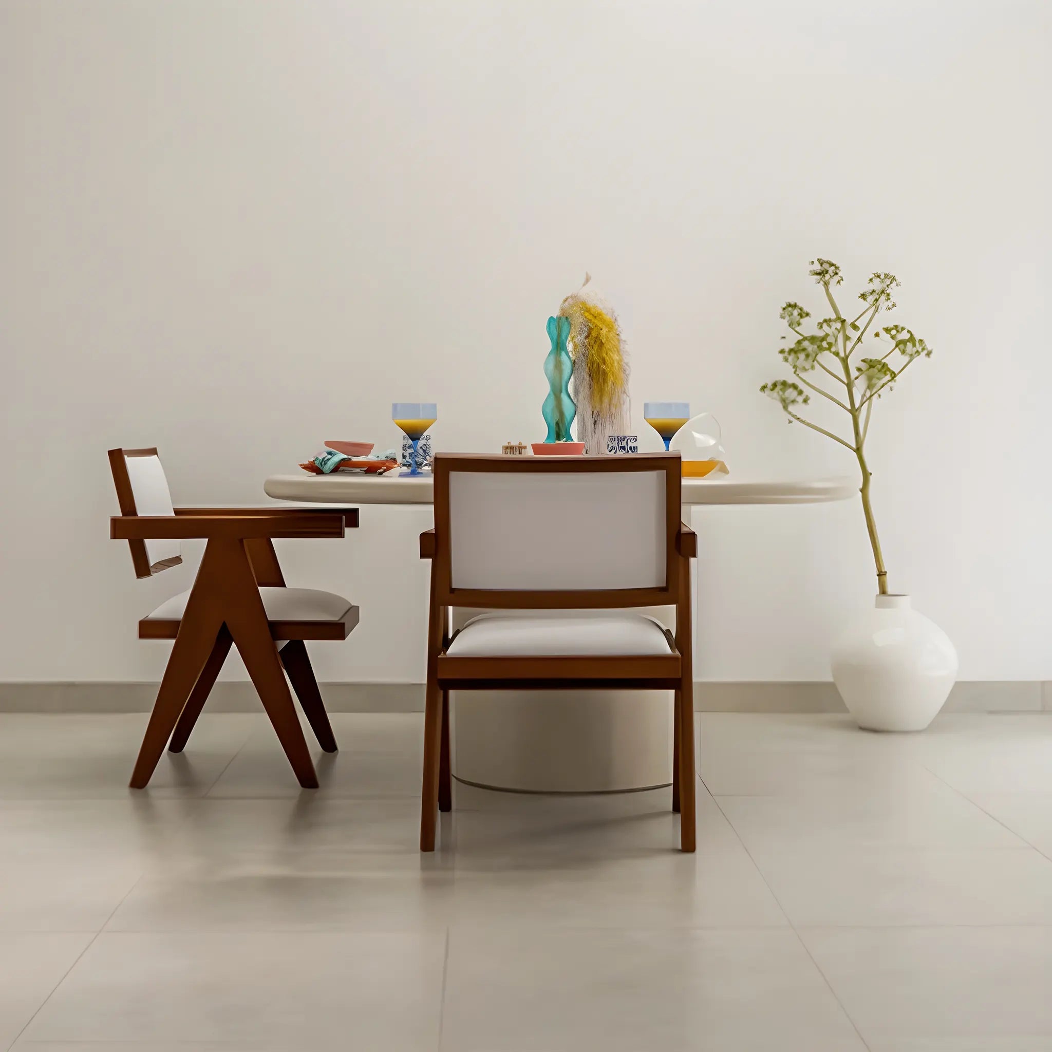Round dining table with a microplaster finish, paired with chic chairs in a vibrant dining space.