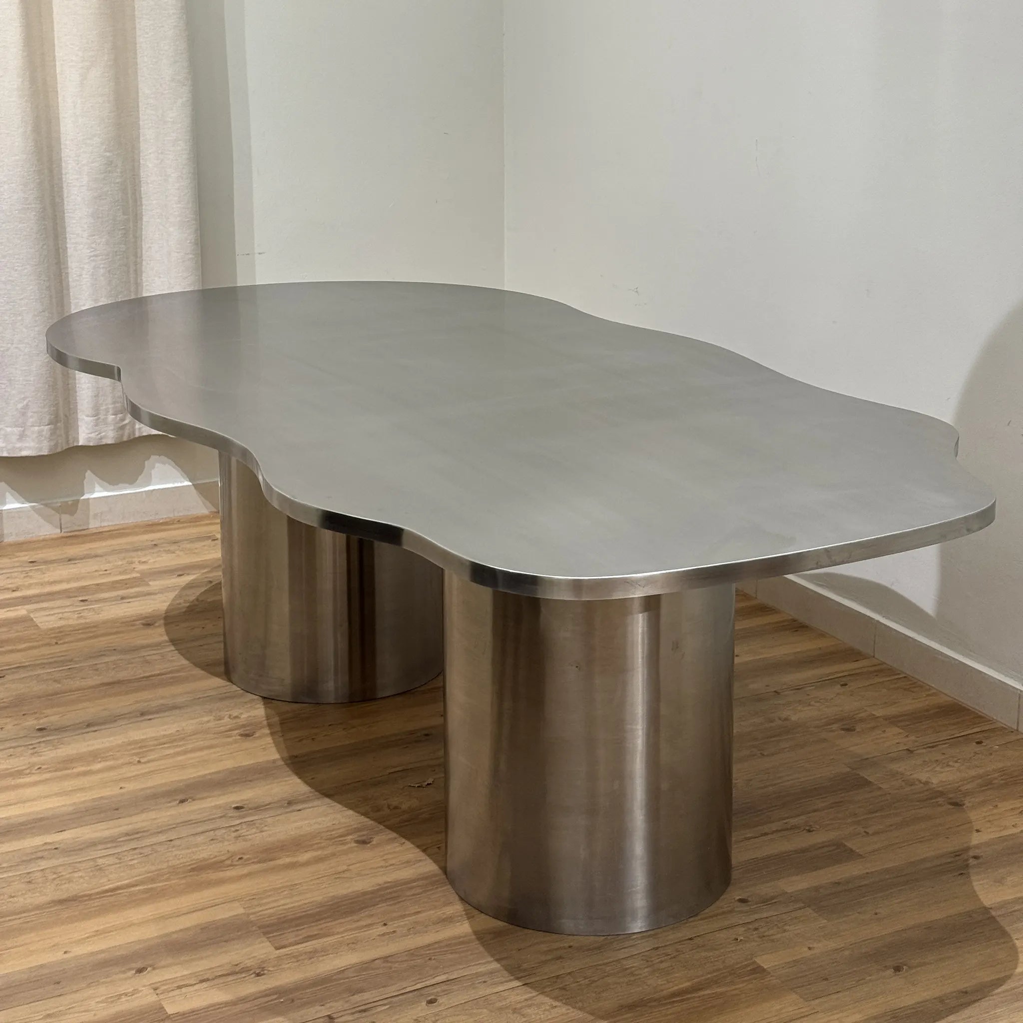 Sleek and modern steel dining table in stainless steel, paired with elegant chairs for a luxurious dining room.