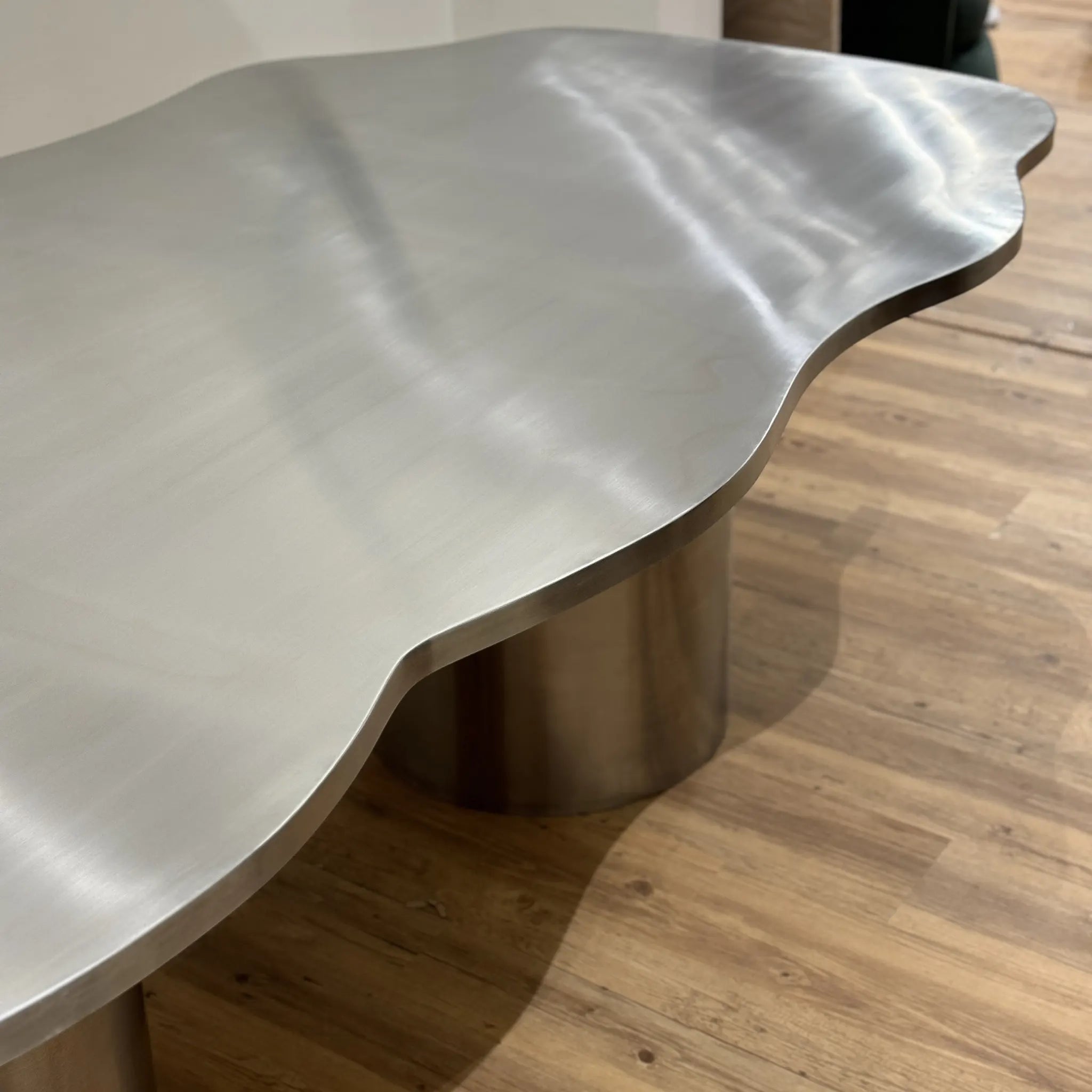 The Victoria steel dining table with a shiny stainless steel top, creating a statement in a contemporary dining room.
