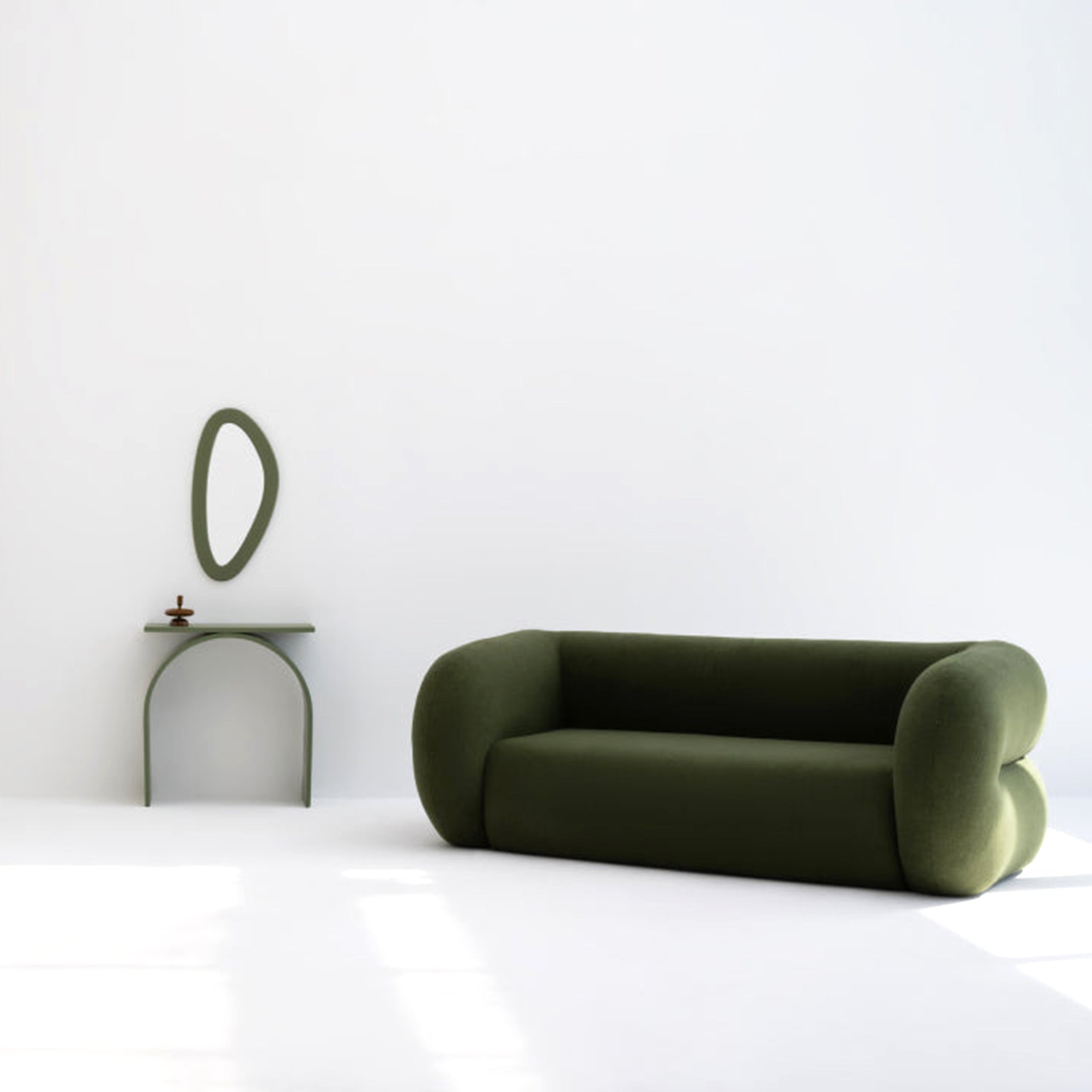 Minimalist living room with a modern green sofa featuring soft, rounded edges, accompanied by a matching side table and a unique oval mirror on a white wall.buy a modern seating sofa