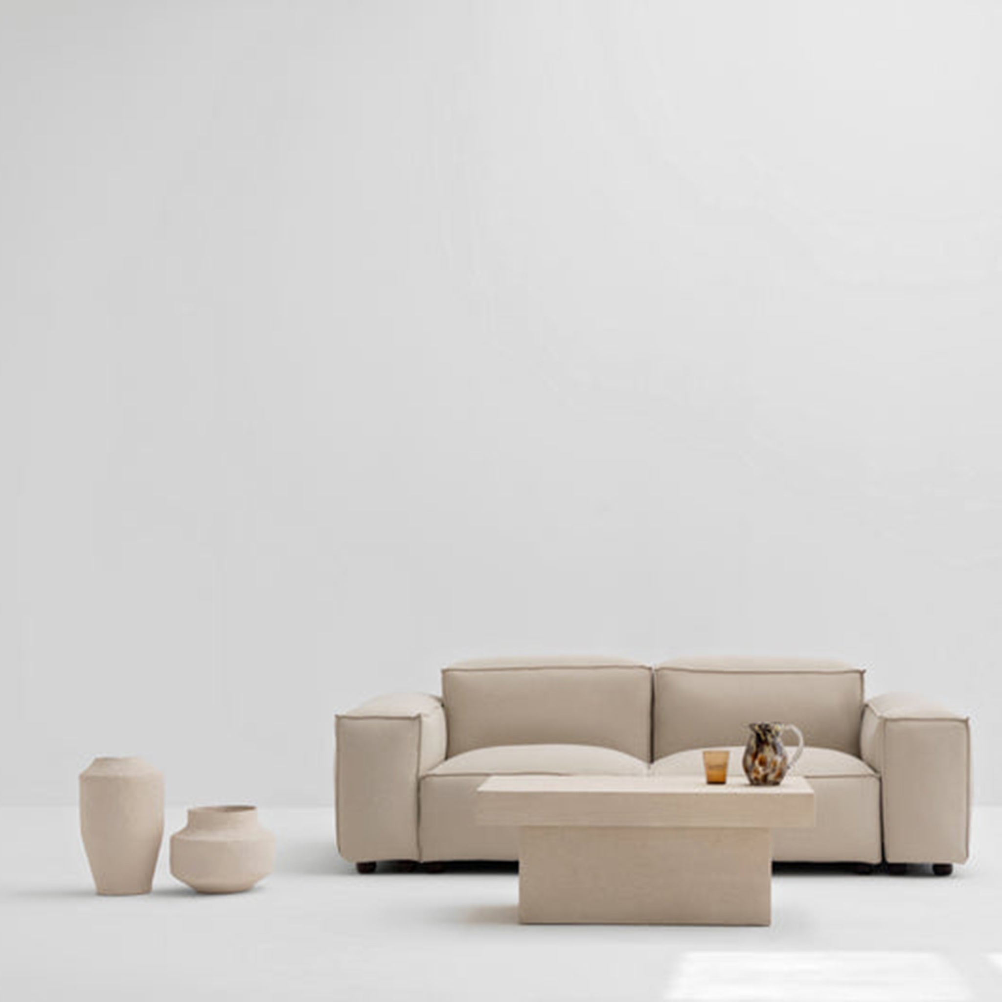 Minimalist beige sofa set with matching coffee table and decorative vases