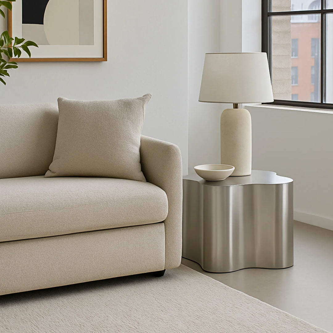 In a bright living room, The Genevive Stainless Steel Coffee Table brings modern sophistication with its reflective surface.