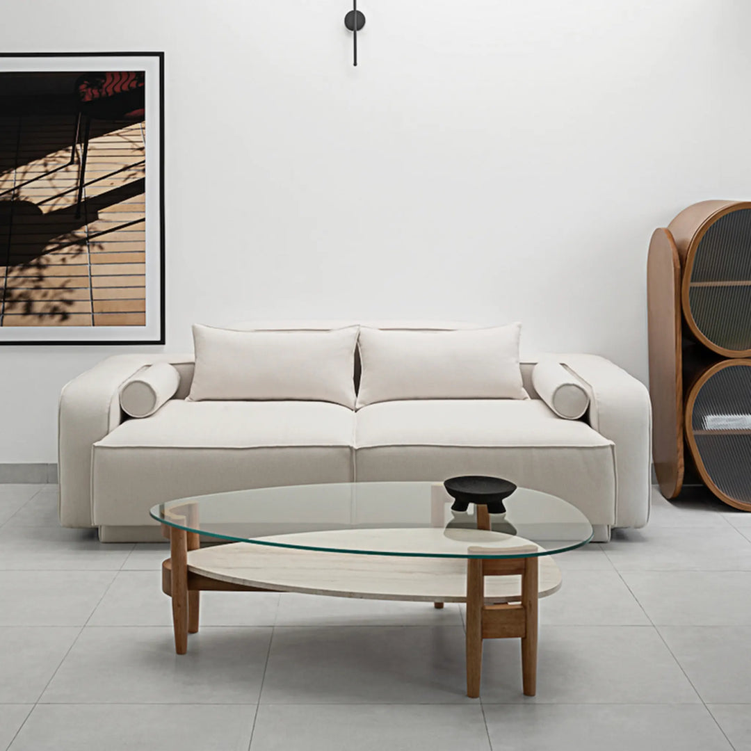 Decor-ready and inviting, The Scott Coffee Table features a round glass surface ideal for showcasing books or floral arrangements, atop a modern wooden base.