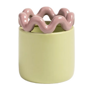 A ceramic planter with a smooth, matte pale yellow-green cylindrical body and a glossy, wavy, wavy-piped rim in a dusty pink color, shown on a light gray background.