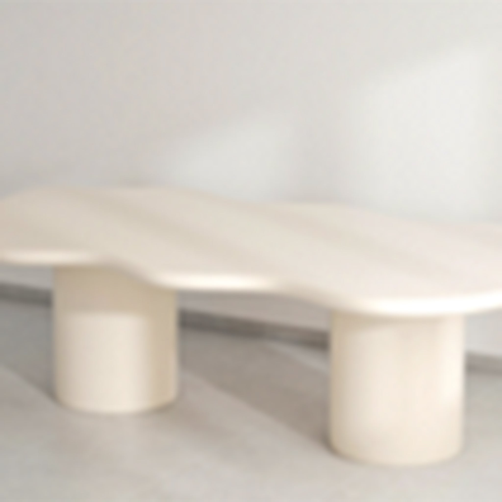 Elegant dining table with a curvy microplaster top and dual cylindrical bases