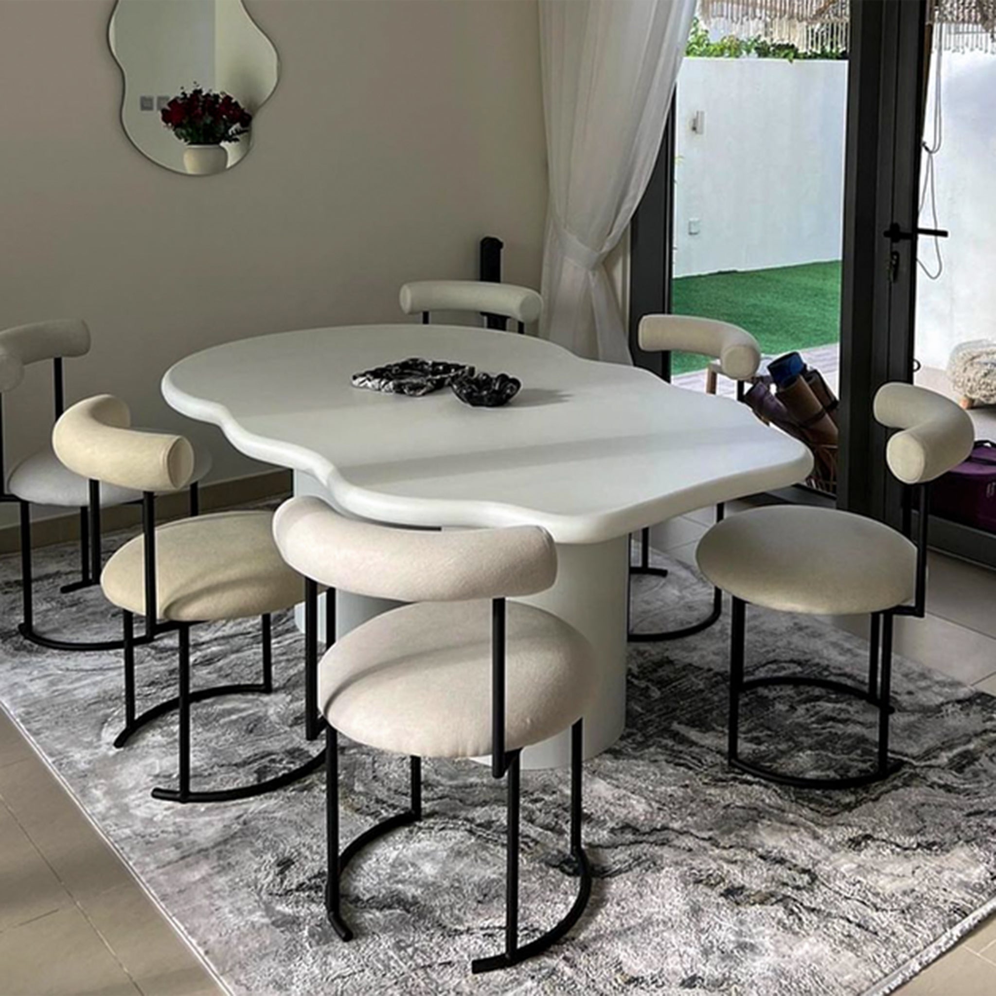 Sophisticated dining table with a curvy top supported by two cylindrical legs