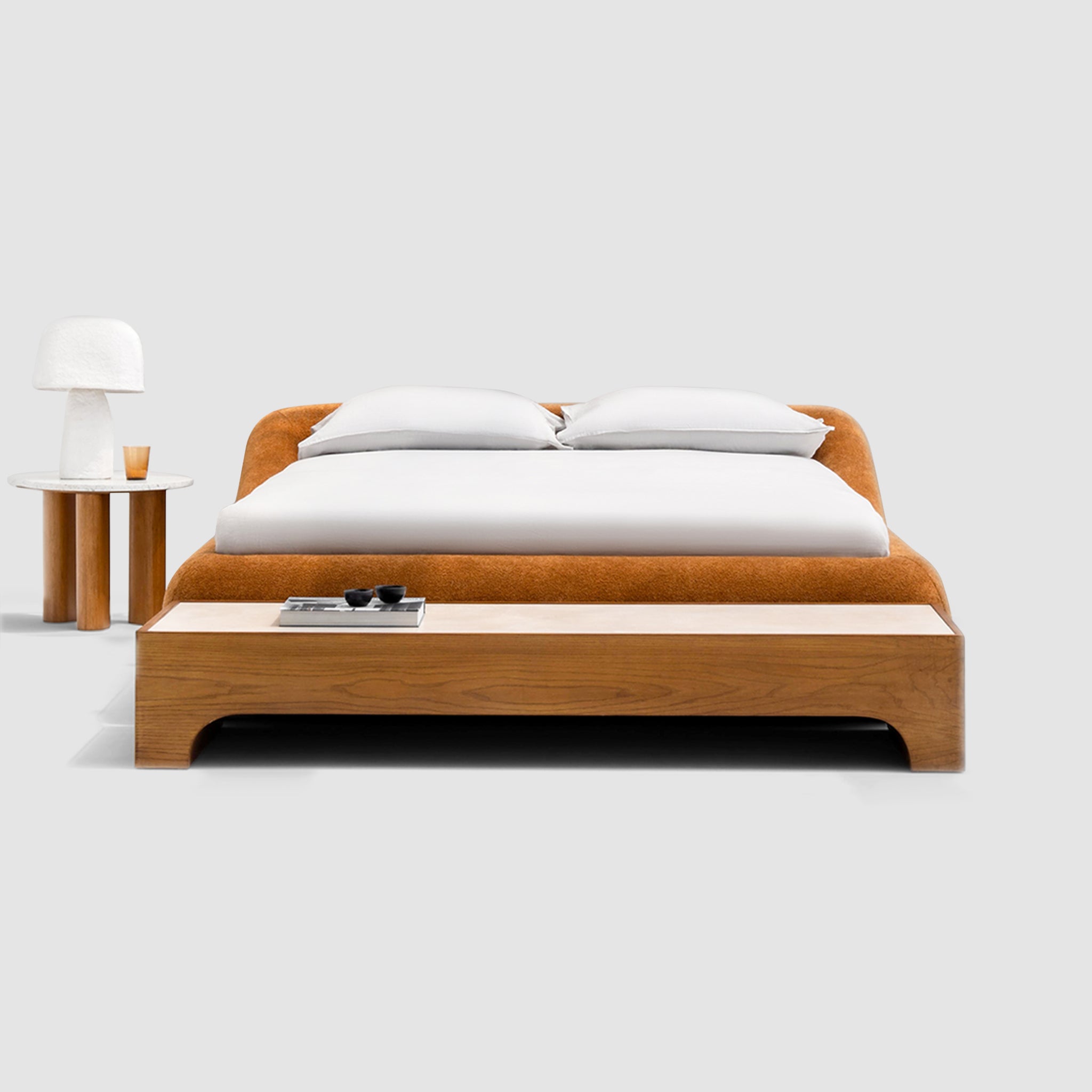 Sleek, charcoal gray king-size platform bed with a minimalist button-tufted headboard rests on a light wood floor. The Alain Bed by Klettkic is crafted from solid wood for a touch of modern luxury in a minimalist bedroom.