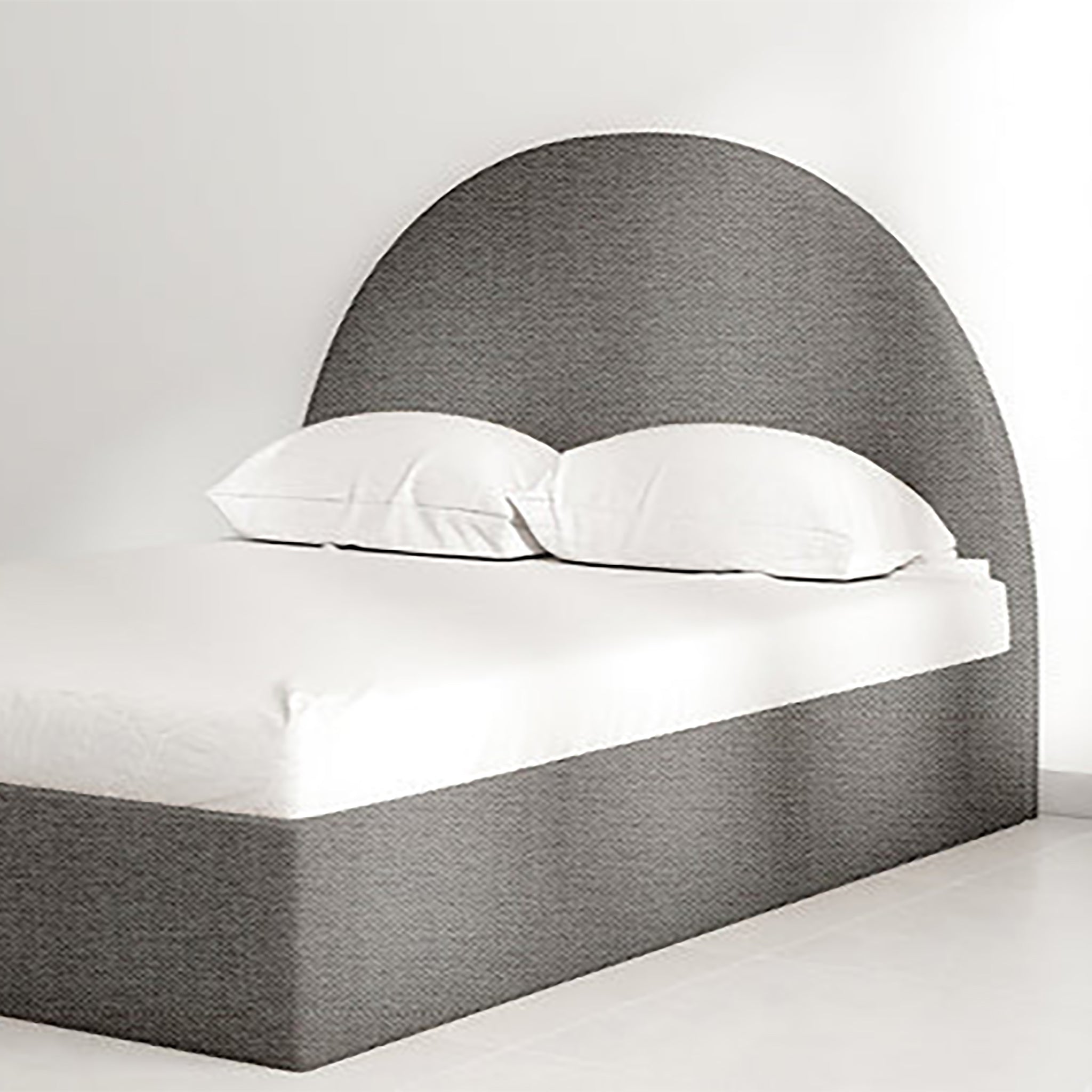 The Archie Bed with a curved headboard in grey upholstery, perfect for modern bedrooms.