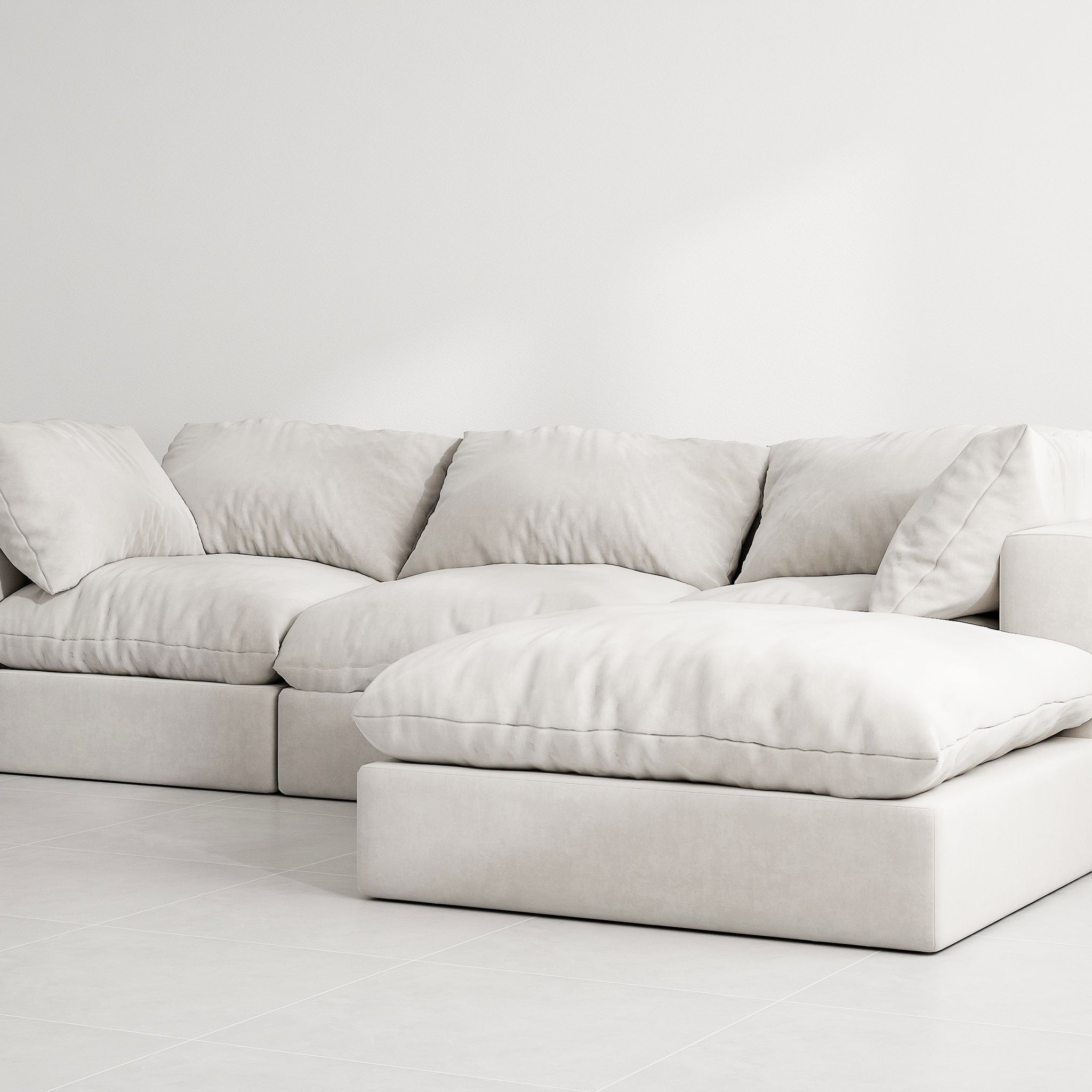 White sectional couch with detachable ottoman in a modern living room. The couch has soft cushions and a solid wood frame.4 Seater Premium Sofa