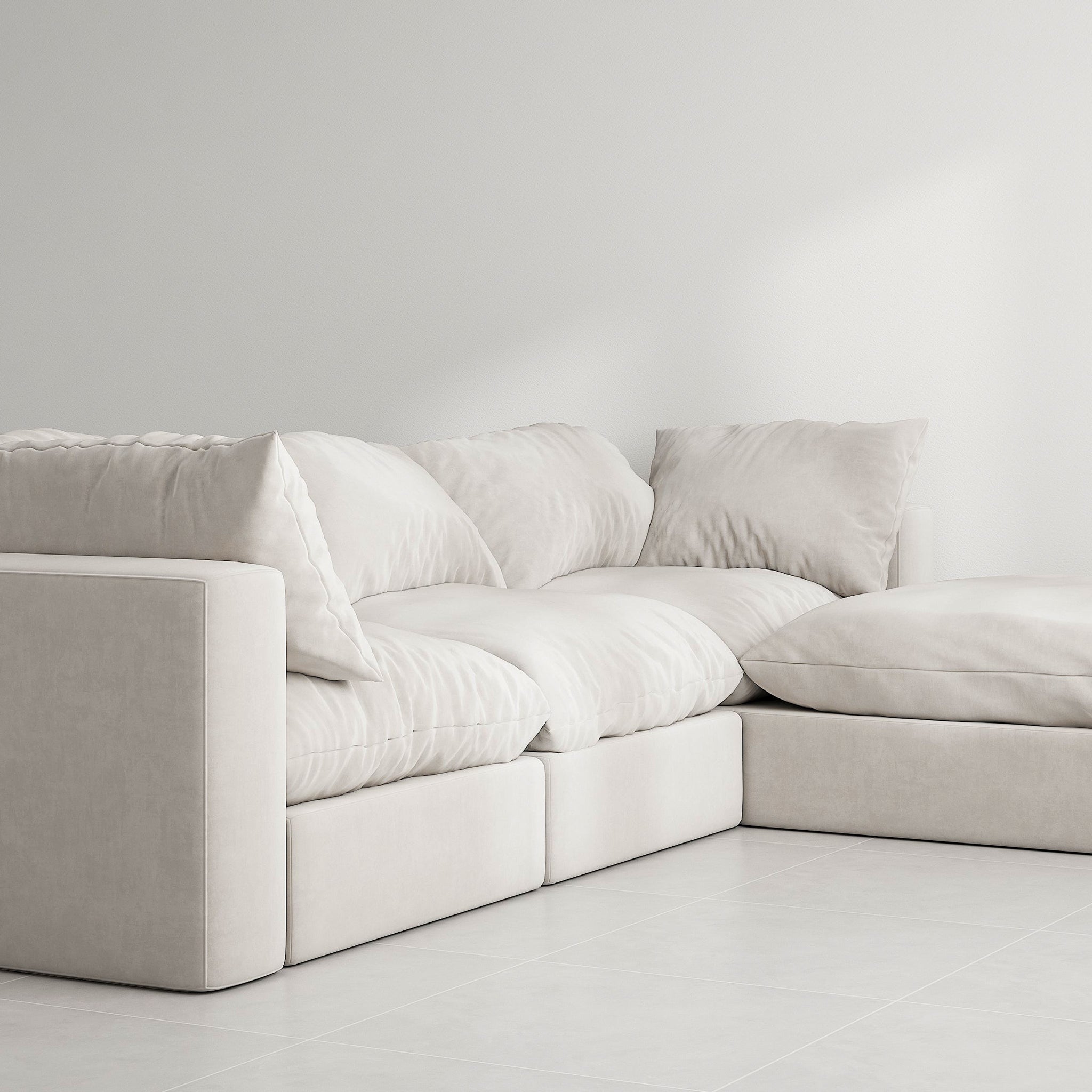 White sectional couch with detachable ottoman in a modern living room. The couch has a solid wood frame and is upholstered in white fabric with removable covers.4 Seater Premium Sofa This luxurious couch is perfect for relaxing in style.