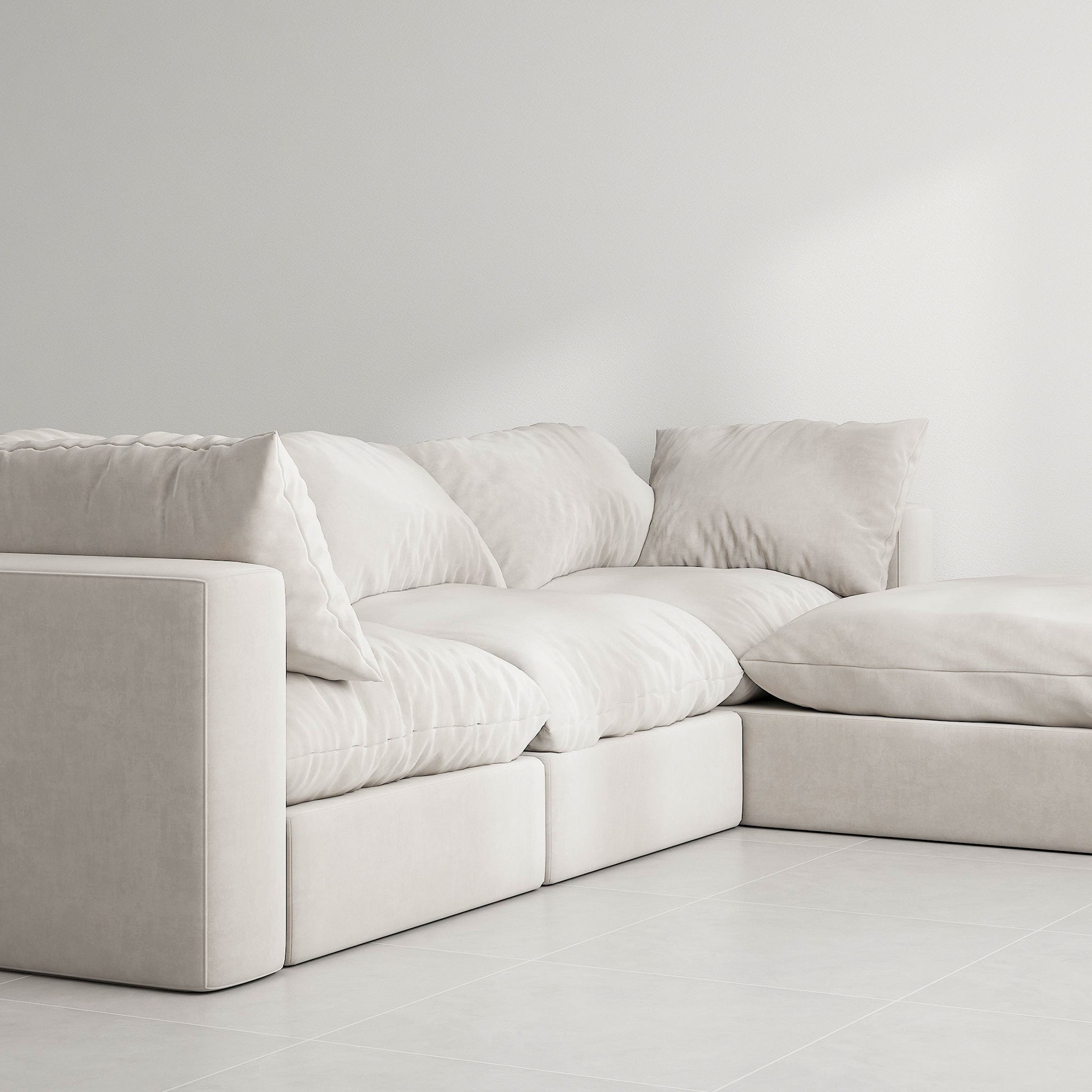 White sectional couch with detachable ottoman in a modern living room. The couch has a solid wood frame and is upholstered in white fabric with removable covers. This luxurious couch is perfect for relaxing in style.