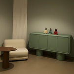 Load image into Gallery viewer, The Barb Microplaster sideboard cabinet placed in a vibrant living room, blending style and practicality.
