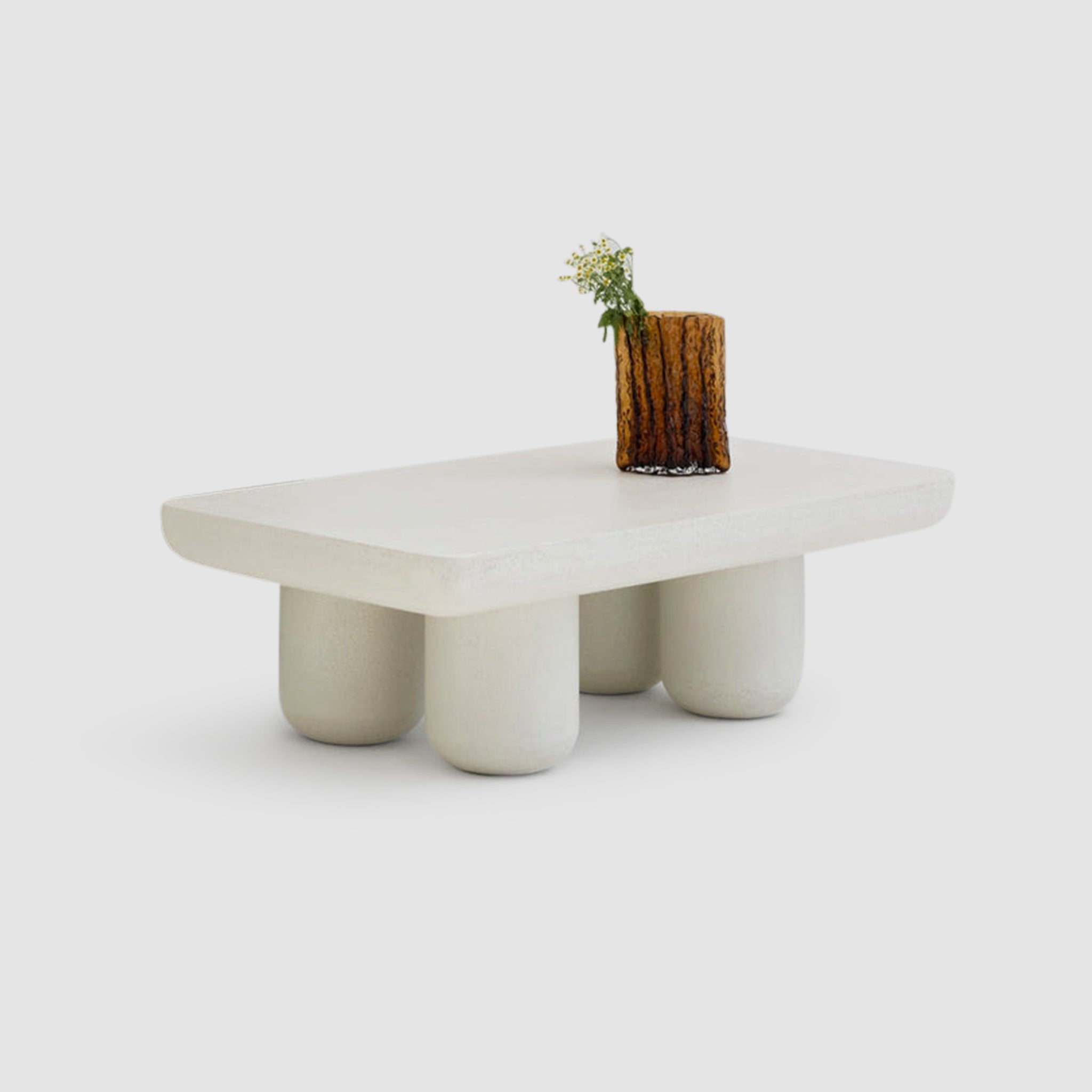Minimalist white coffee table with rounded legs and a small decorative vase