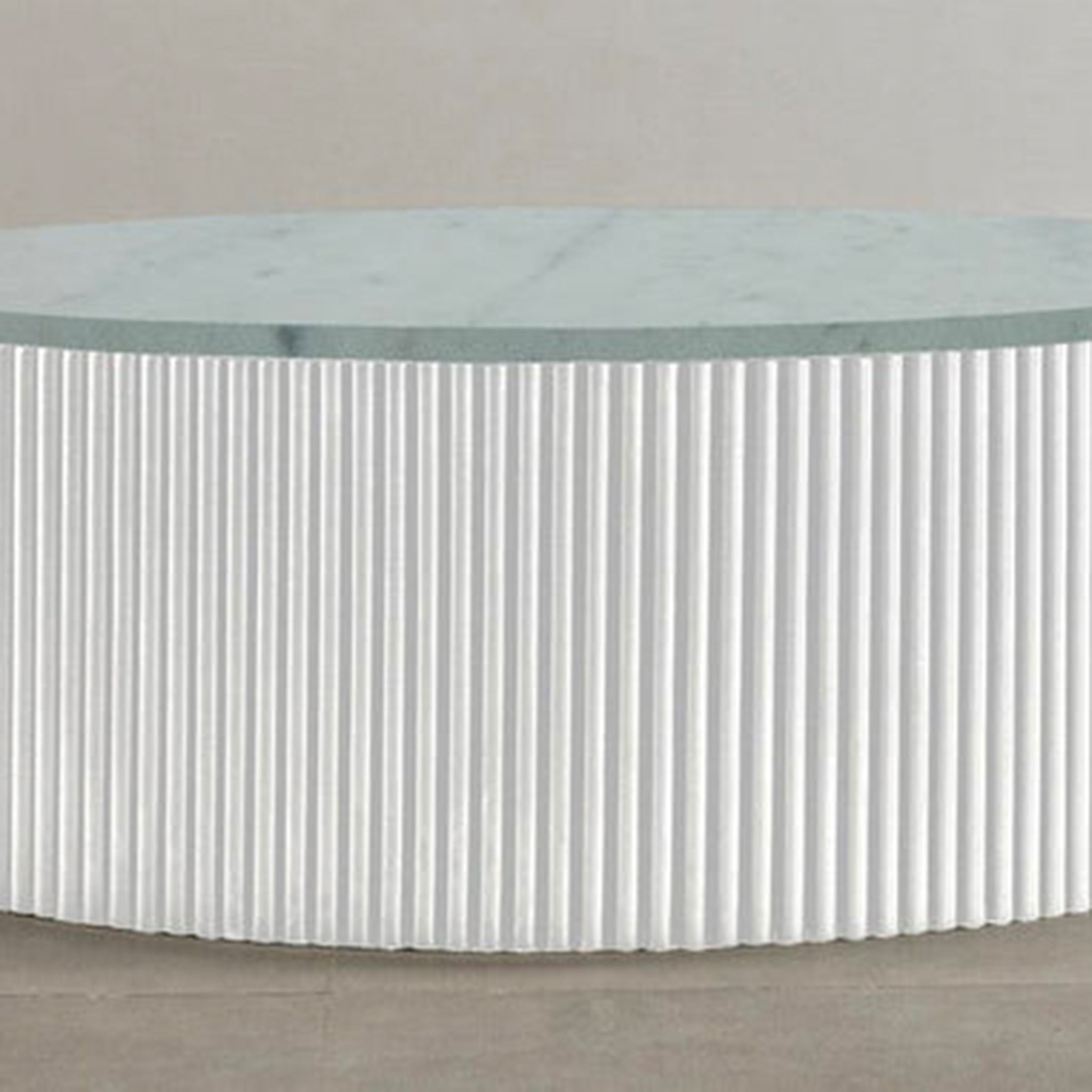 "Elegant circular table with fluted sides and smooth top"