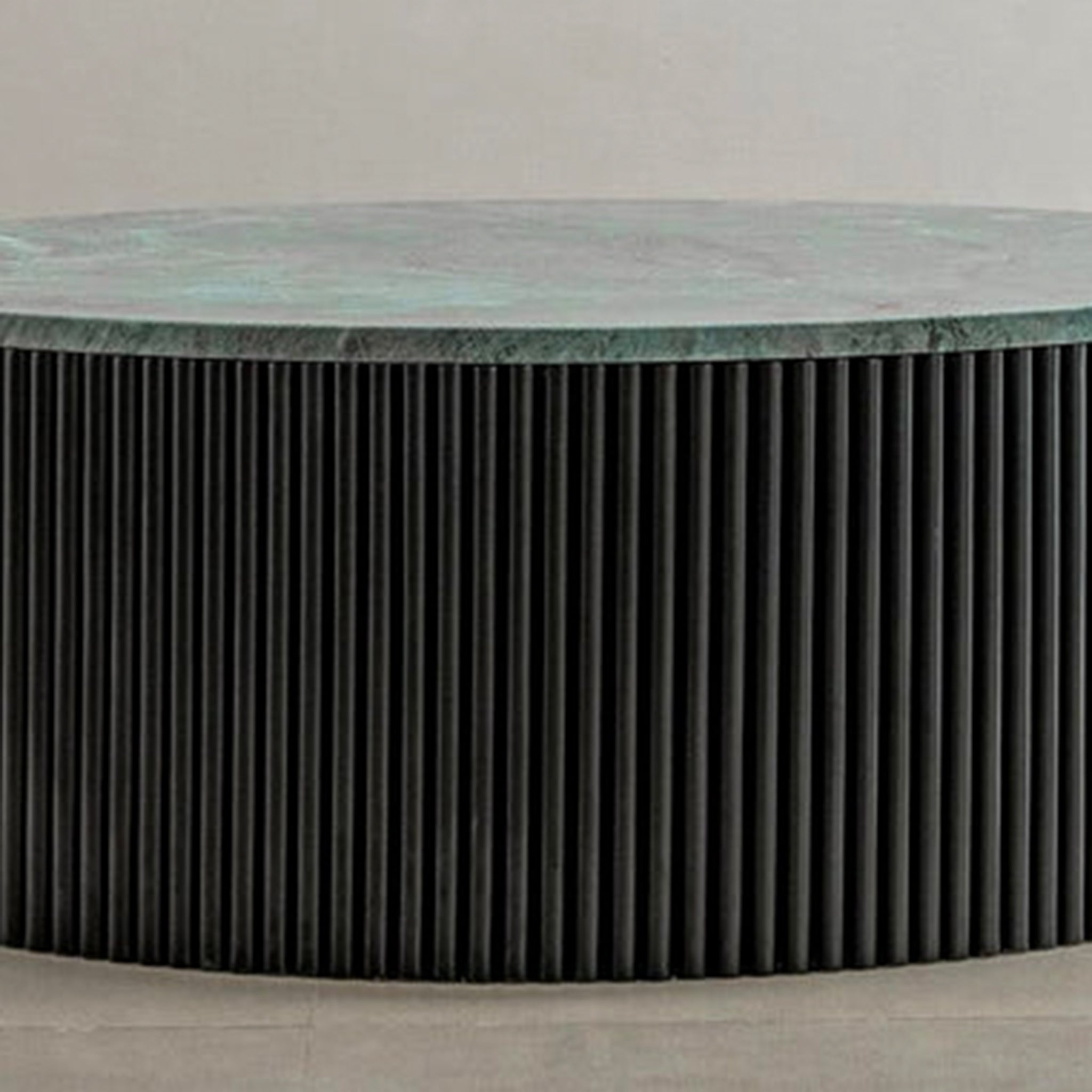 "Sleek coffee table with green stone top and ribbed base"