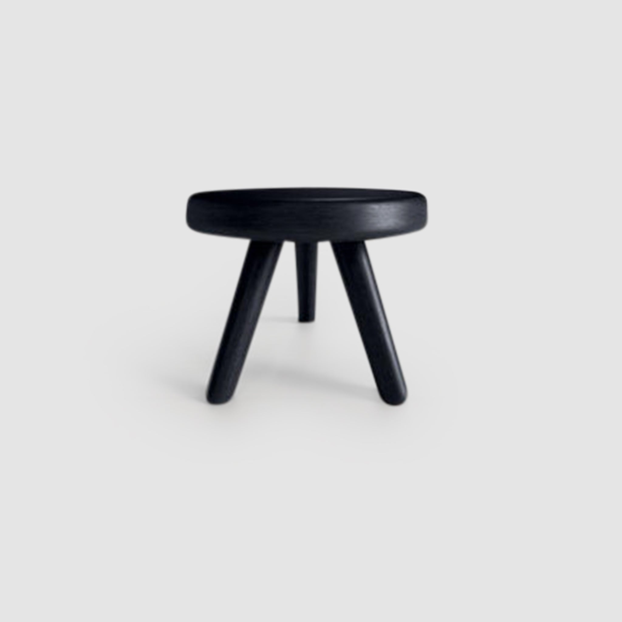 Black wooden three-legged mini stool with a round seat