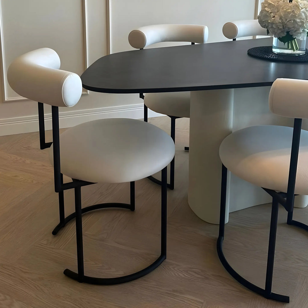 The Claudia round dining chair, featured in a stylish dining area with a sleek wooden table.