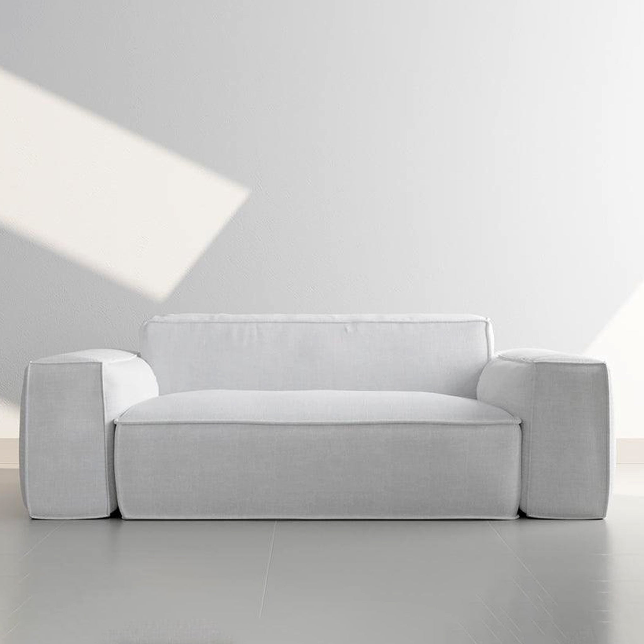 Comfortable beige couch with plush cushions in a minimalist living space. 