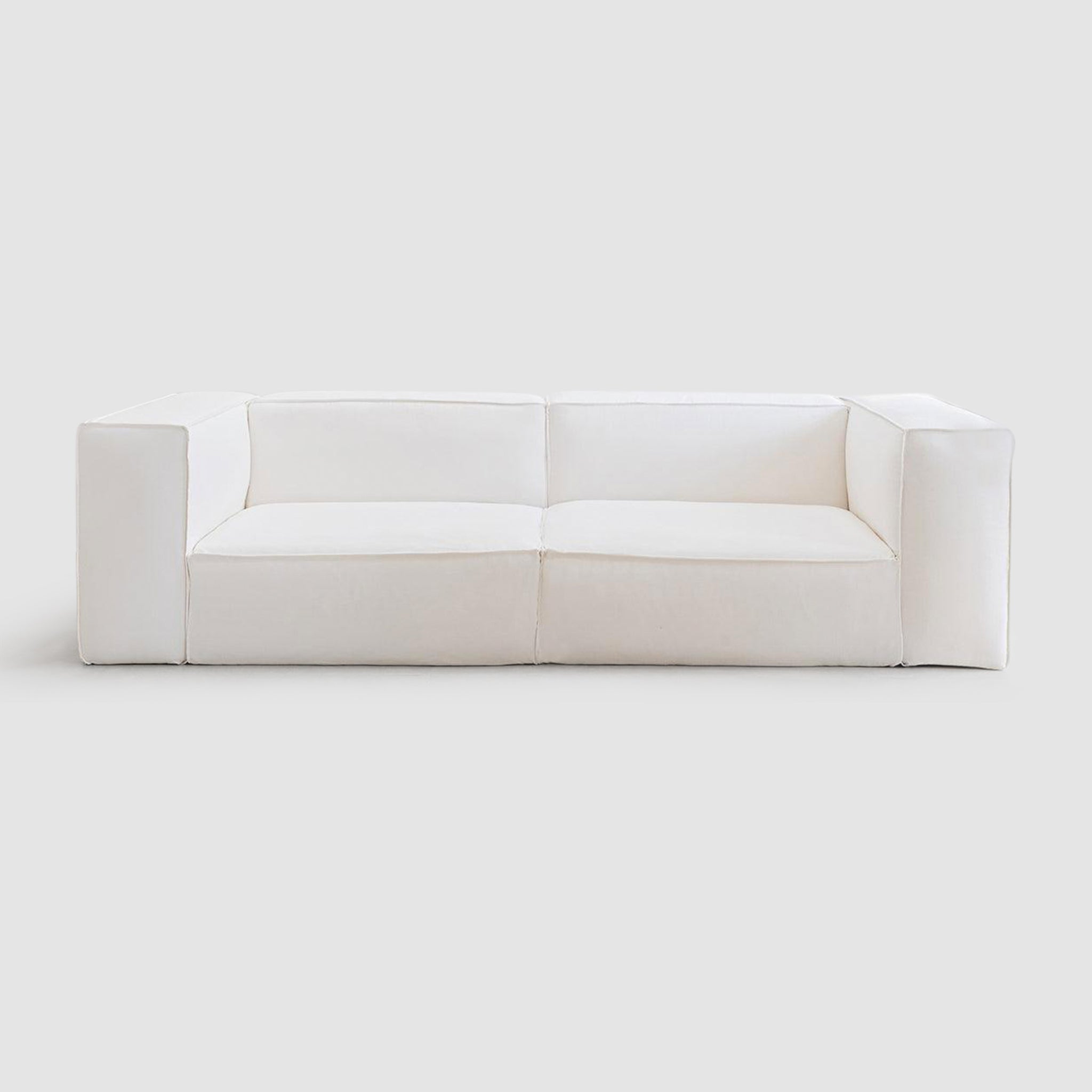 Front view of a minimalist white modular couch with wide armrests and plush cushions, perfect for modern living room decor.