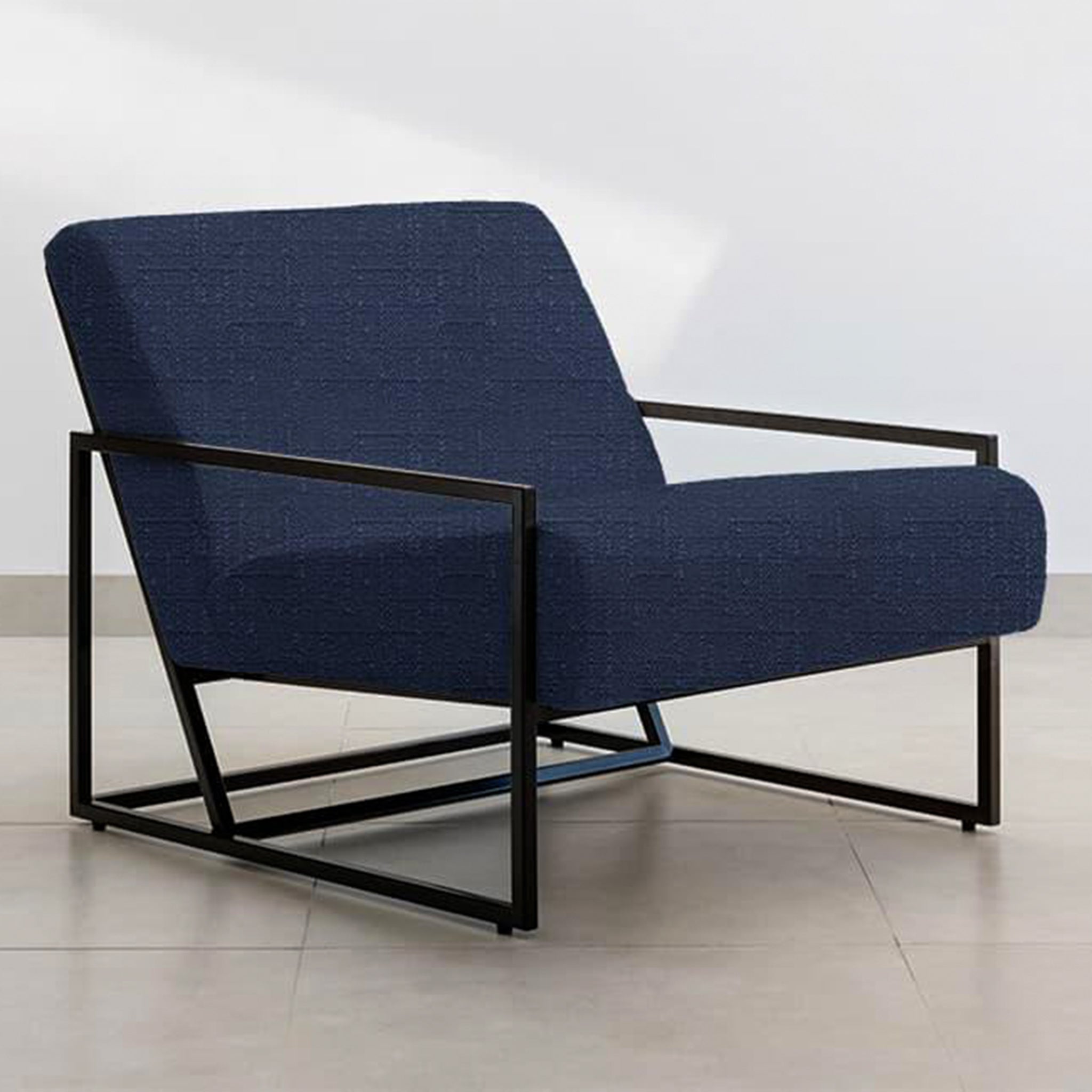The Daphne Accent Chair with a sleek navy blue fabric and black metal frame, positioned in a modern living room.