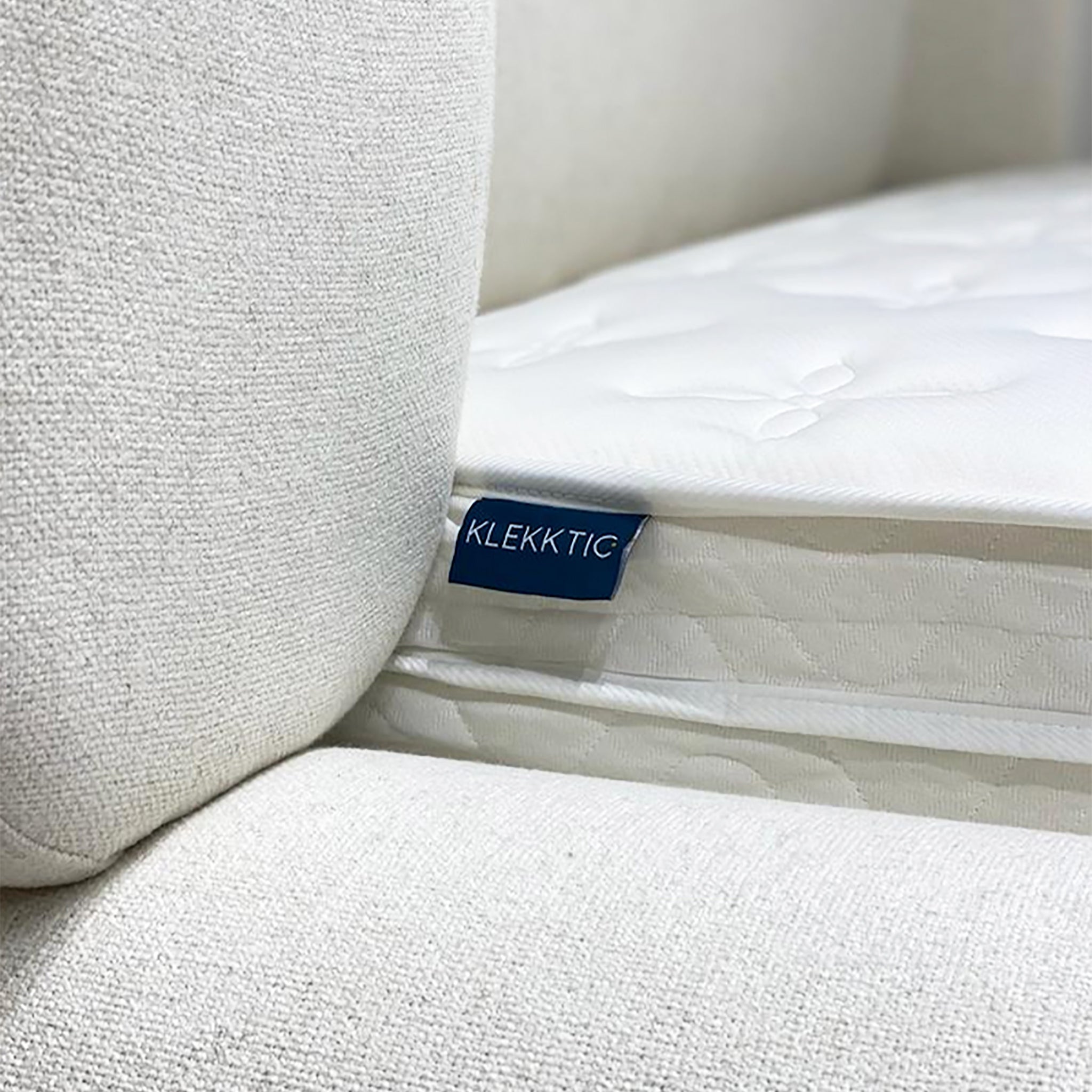 Plush white EuroTop mattress with a breathable knitted top sits beside a white couch. The Douglas EuroTop Mattress offers 30cm of comfort and supportive pocket springs.