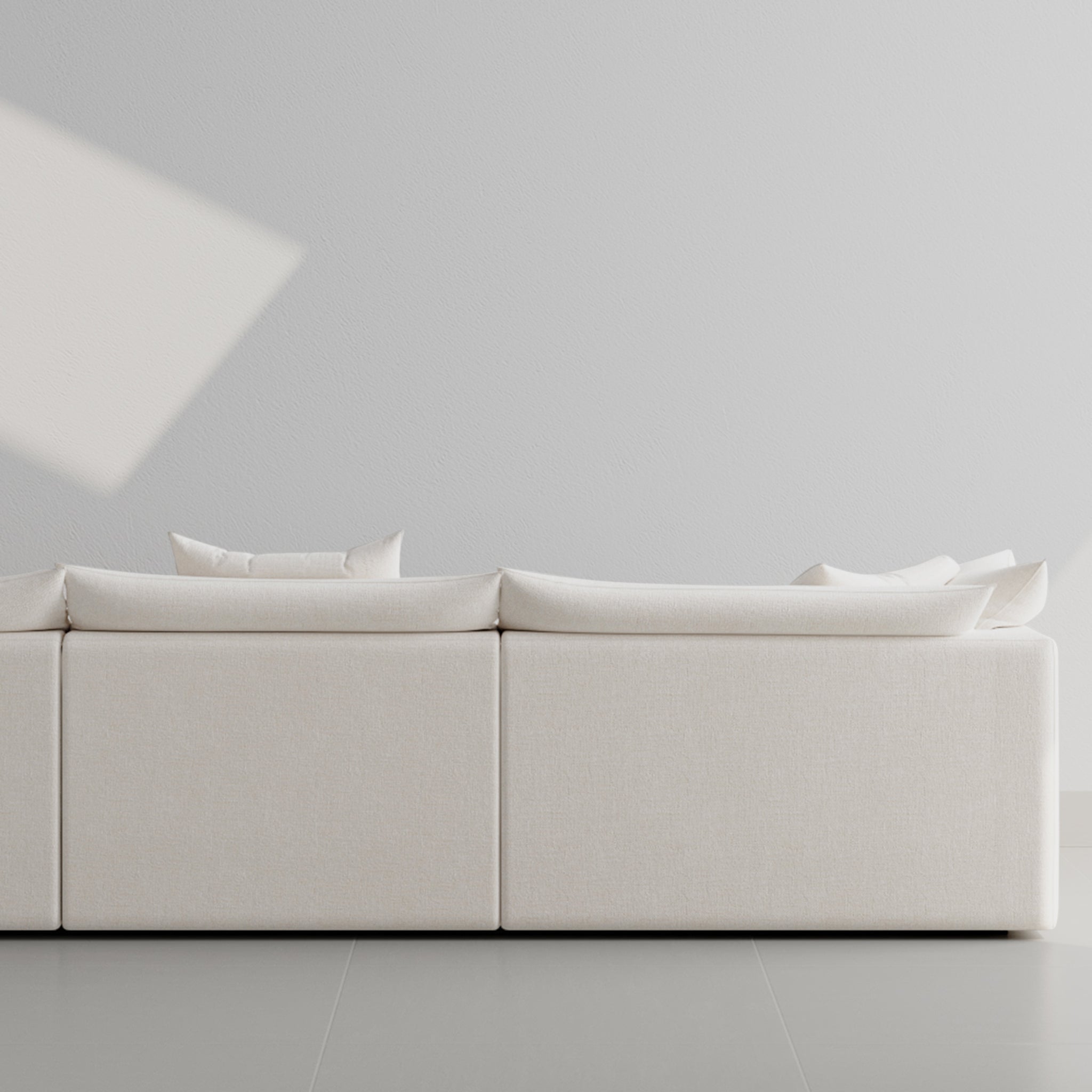 White two-seater sofa with plush cushions in a modern living room setting. 