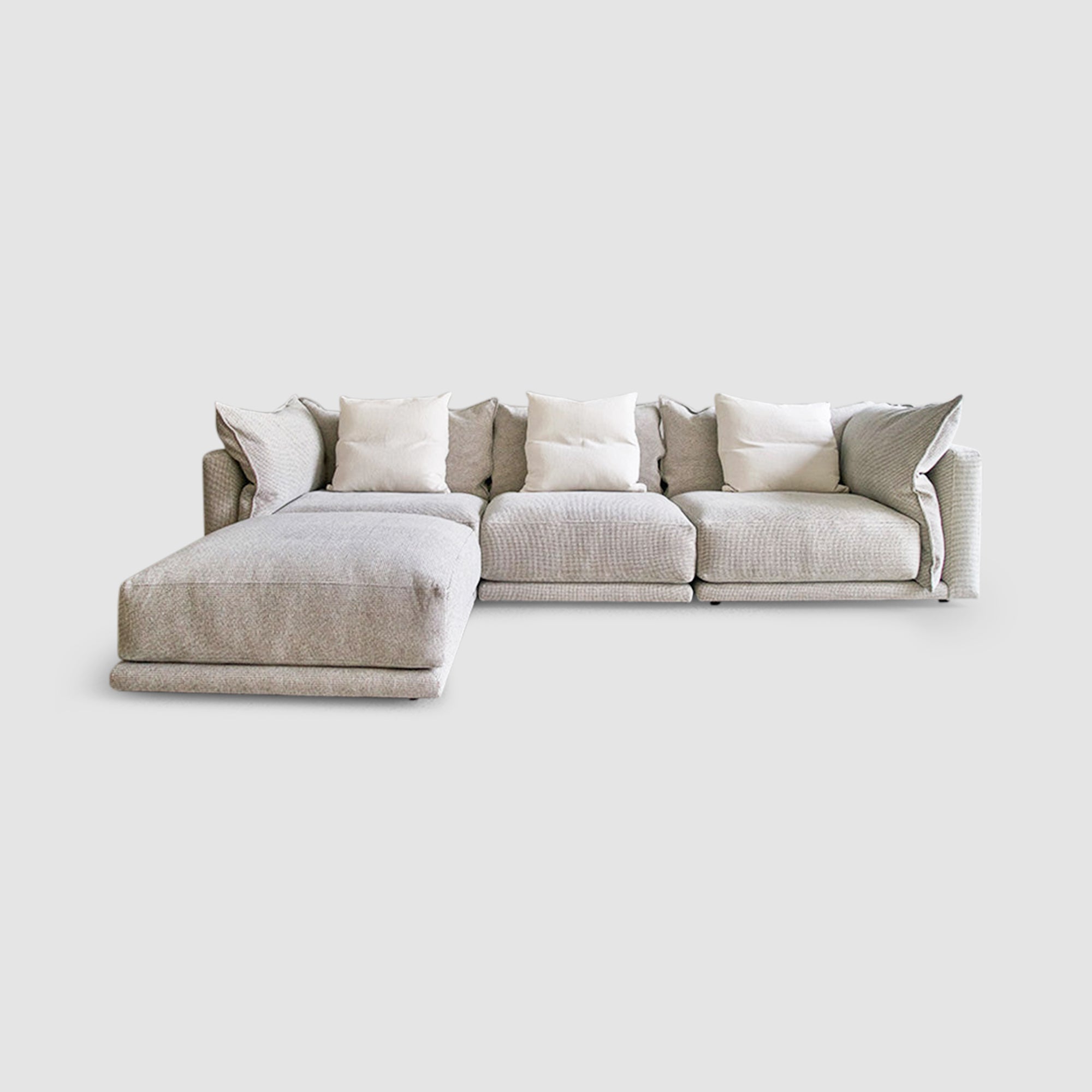 Modern grey sectional sofa with white cushions in a contemporary living room setting, ideal for stylish and comfortable home decor.