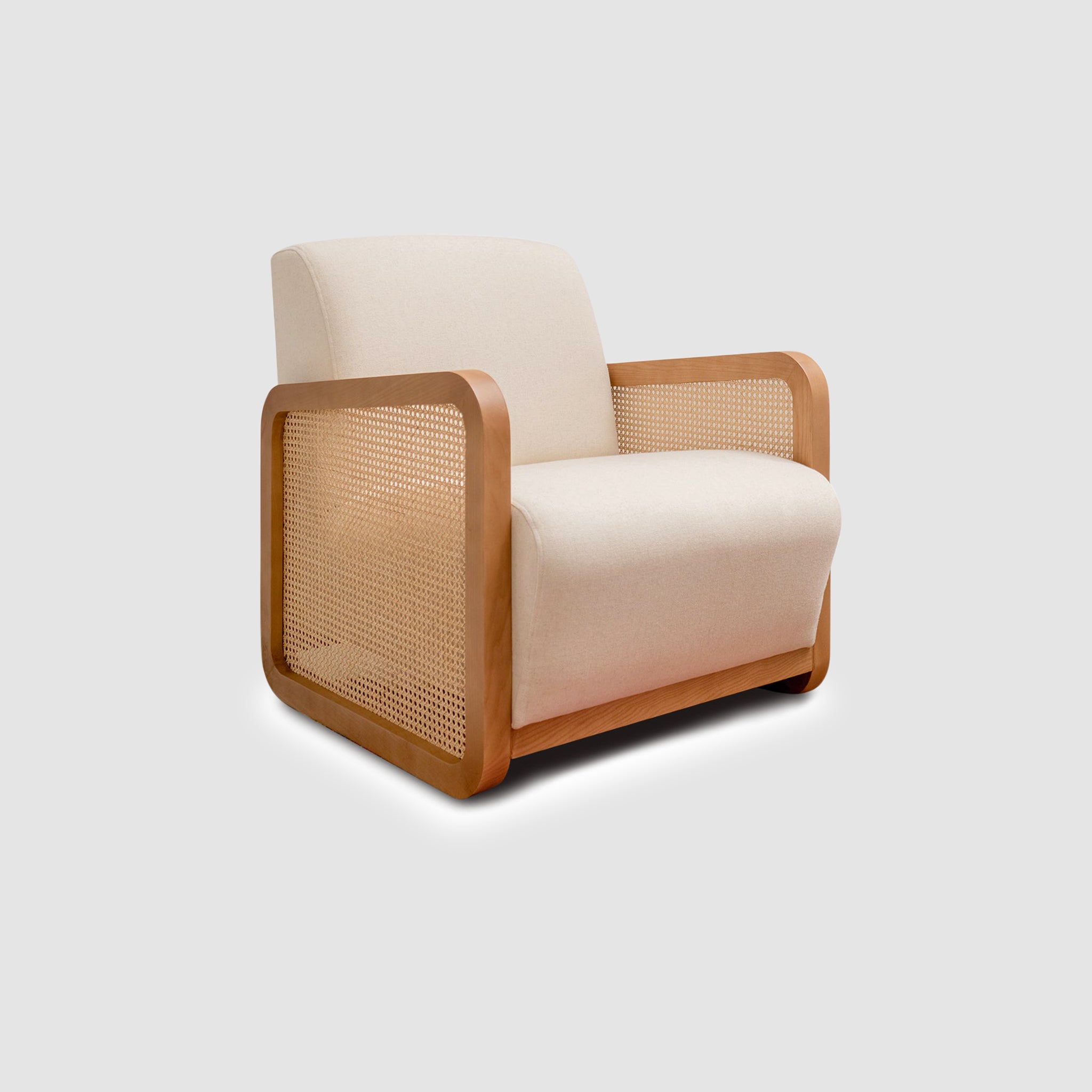 Modern design of The Georgia Accent Chair featuring a beige upholstered seat and curved wooden frame with woven cane sides, angled view.