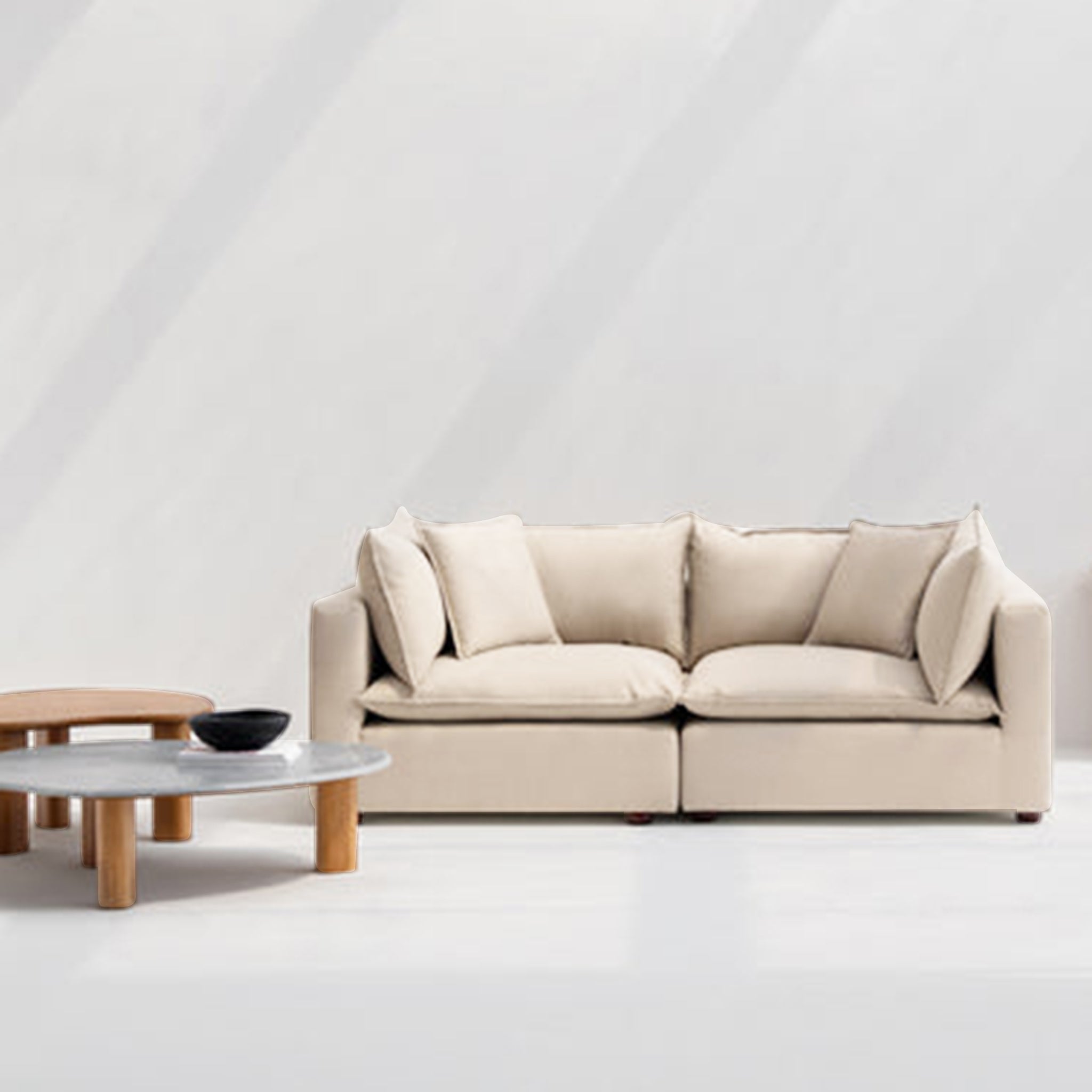 Beige loveseat sofa with plush cushions in a modern living room setting, complemented by wooden coffee tables and minimalist decor.