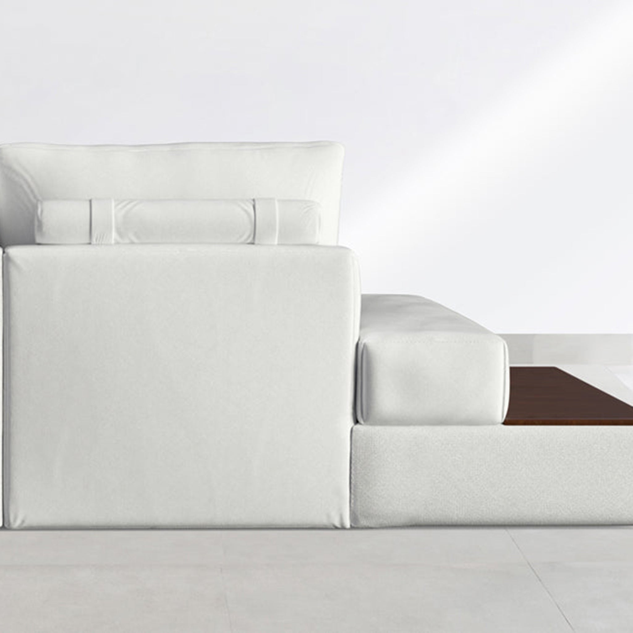 Close-up view of a modern white sofa with a built-in wooden side table, highlighting the sleek design and comfortable seating.