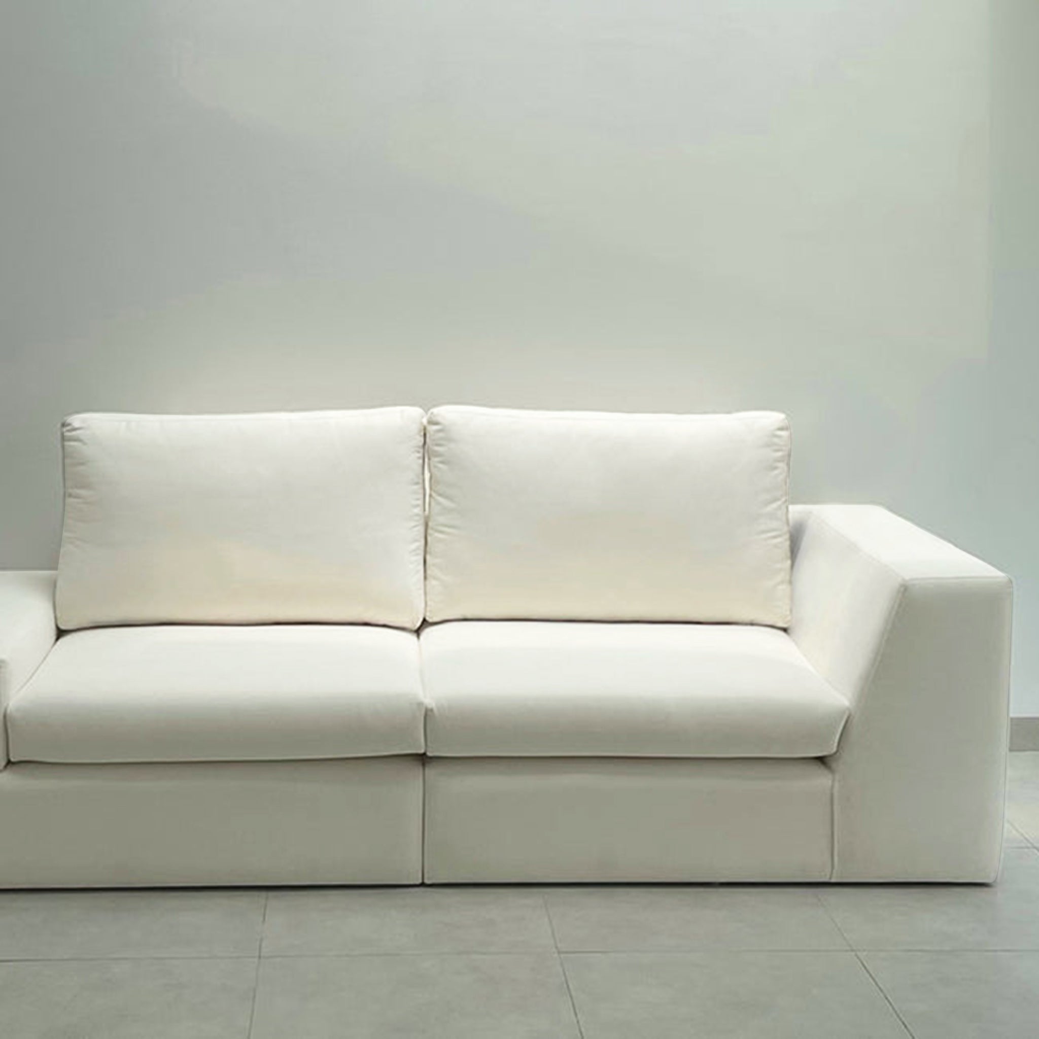 Side view of a modern white sofa showcasing clean lines and plush cushions, ideal for a sleek and minimalist living room decor.