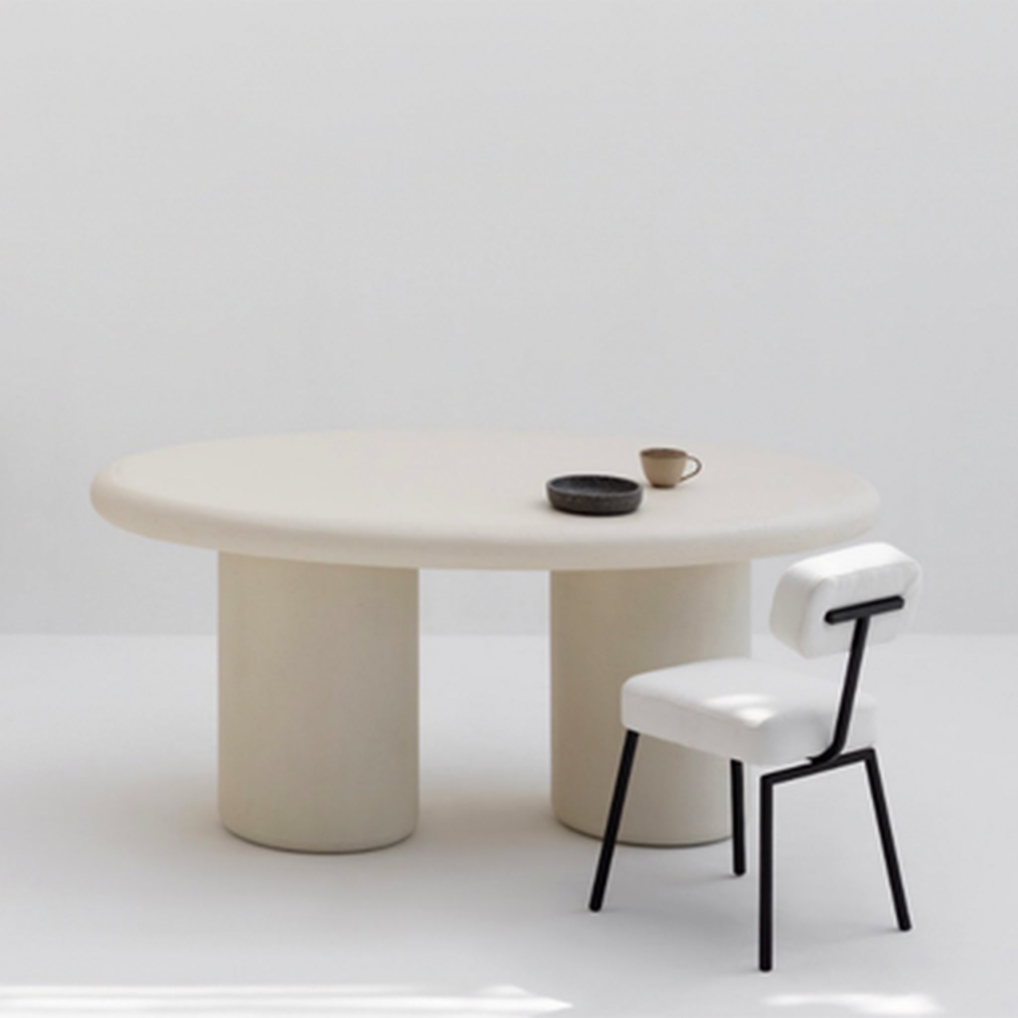 The Ida Dining Chair - sleek black steel frame with white cushioned seat and backrest, paired with a modern round dining table in a minimalist setting.