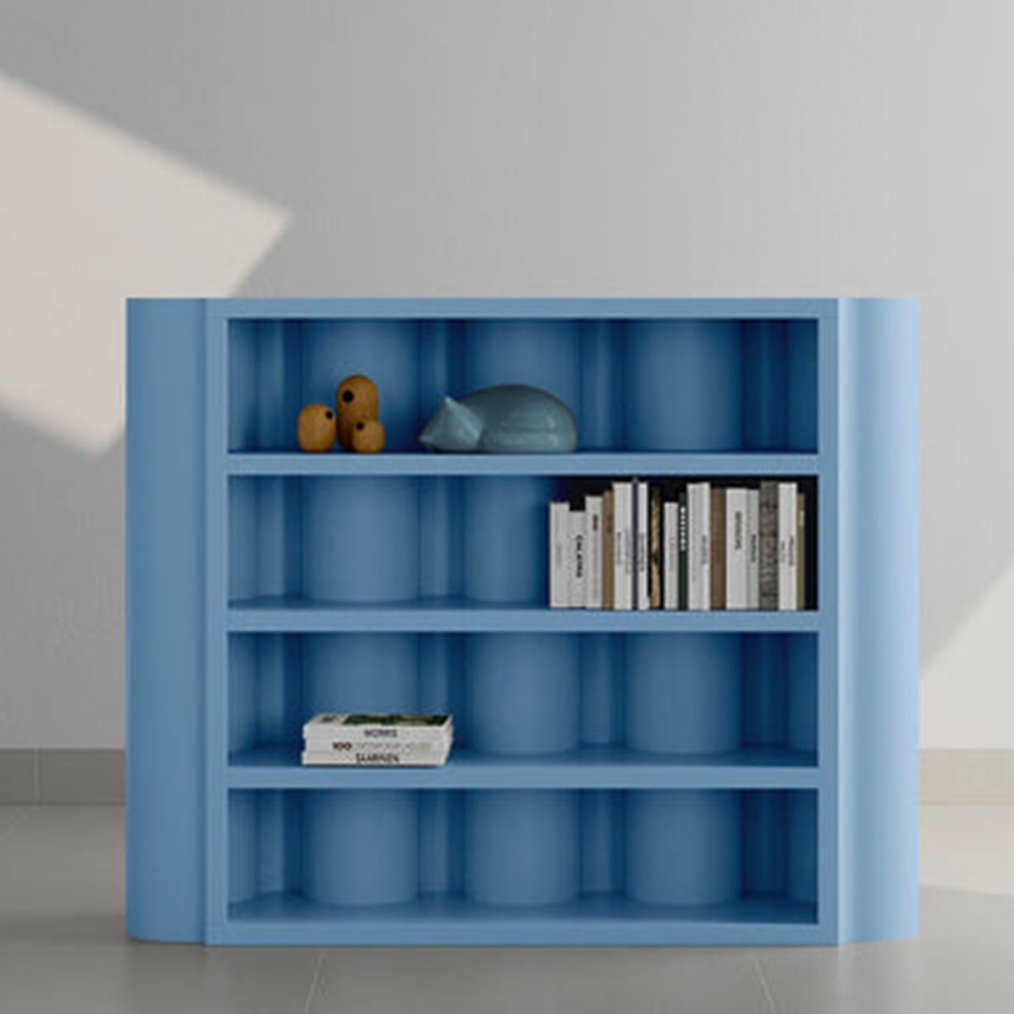 A modern blue bookcase with curved sides, featuring a selection of books and decorative items on its shelves.