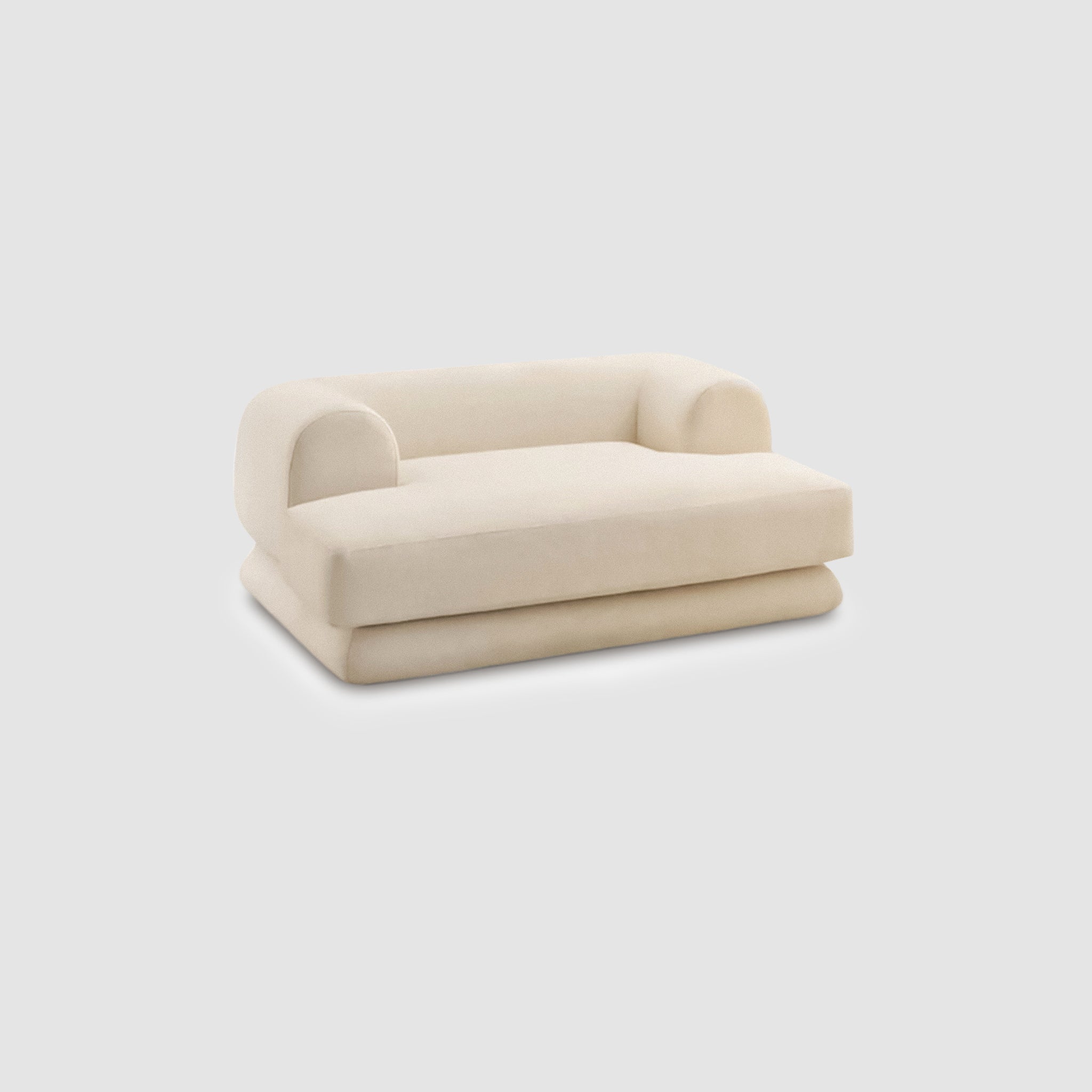 "Angled view of The Lewis Low Lounger Accent Chair featuring plush beige upholstery, low-profile design, and rounded armrests, set against a plain background."