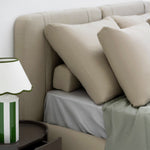 Load image into Gallery viewer, The Ruby Bed fully upholstered with two bolster pillows and three oversized feather-filled cushions, featuring a sleek frame design, in a contemporary bedroom setting. Bed buy dubai online
