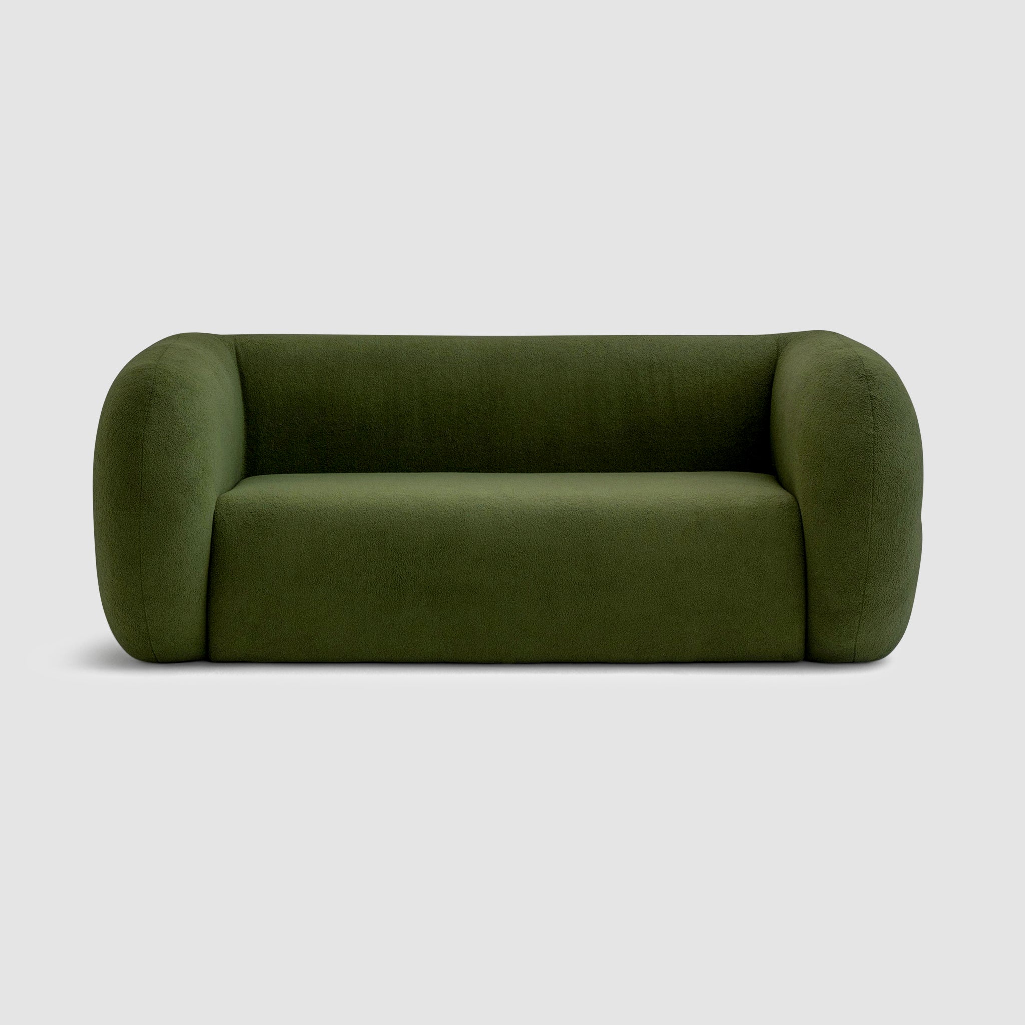 The Ruthie Sofa in green fabric, showcasing its unique, rounded design with curves, and a smooth back and sides that are as captivating as the front. The 2m sofa comfortably seats 2-3 people and features medium-soft cushions for ultimate comfort.