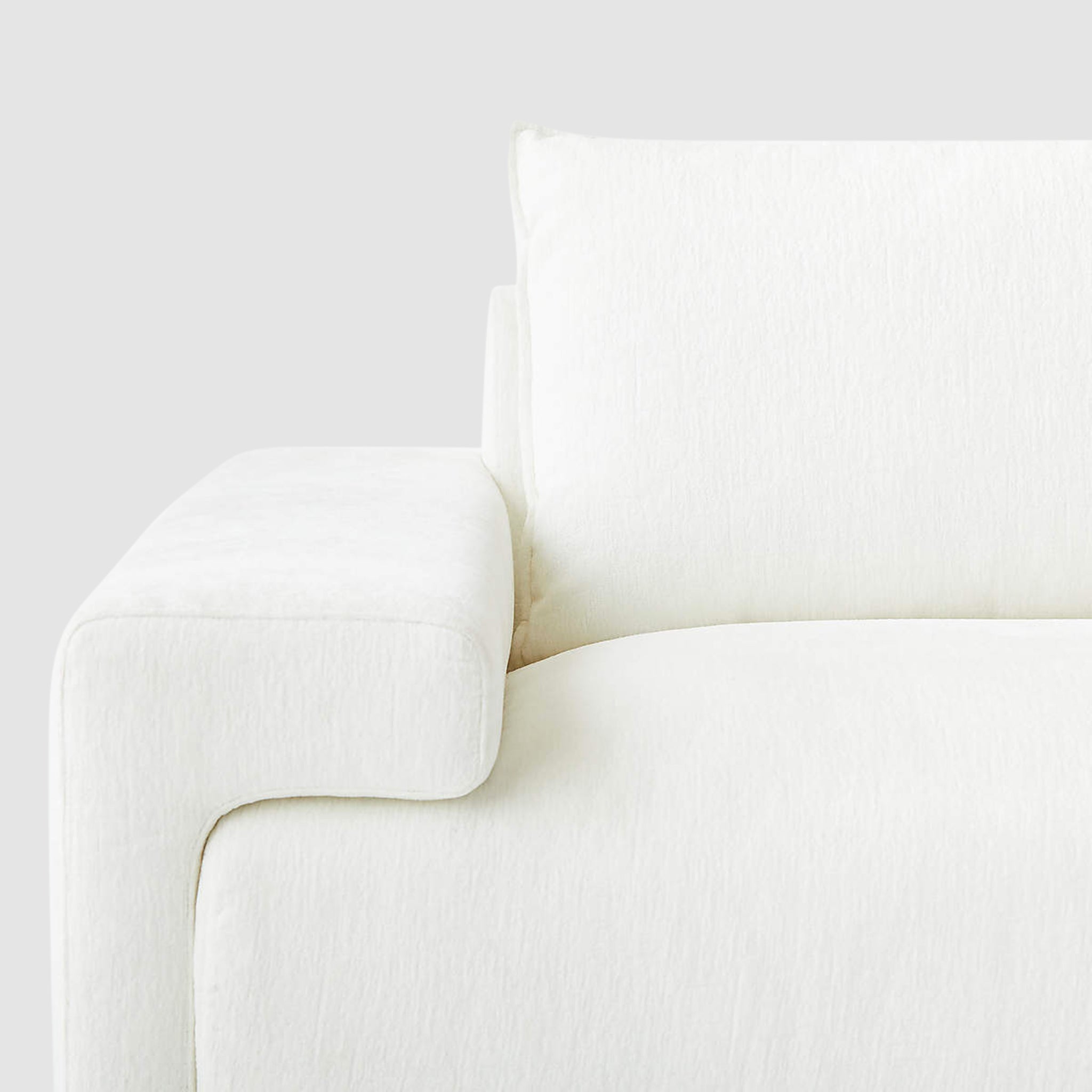 Close-up view of modern minimalist white Sylvia sofa armrest and cushion detailing, highlighting plush comfort and sleek design for a stylish living room