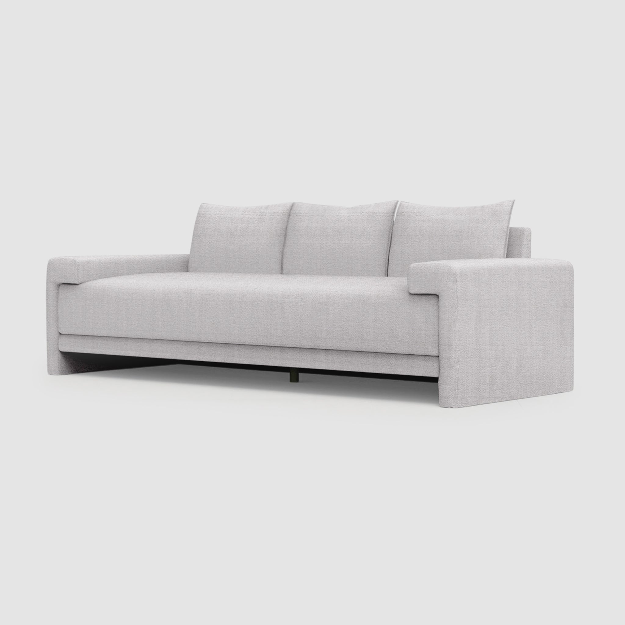 A long, modern sofa with a modern design. It has three large, plush back cushions and two square throw pillows. The arms are straight and the sofa sits on a lifted base with curved black metal legs.