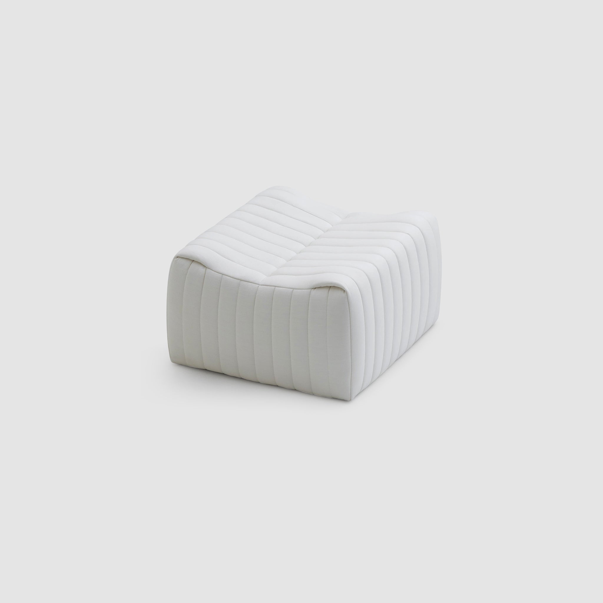 Modern white upholstered ottoman with a sleek, quilted design, featuring curved edges and horizontal stitching, known as The Wren Ottoman.