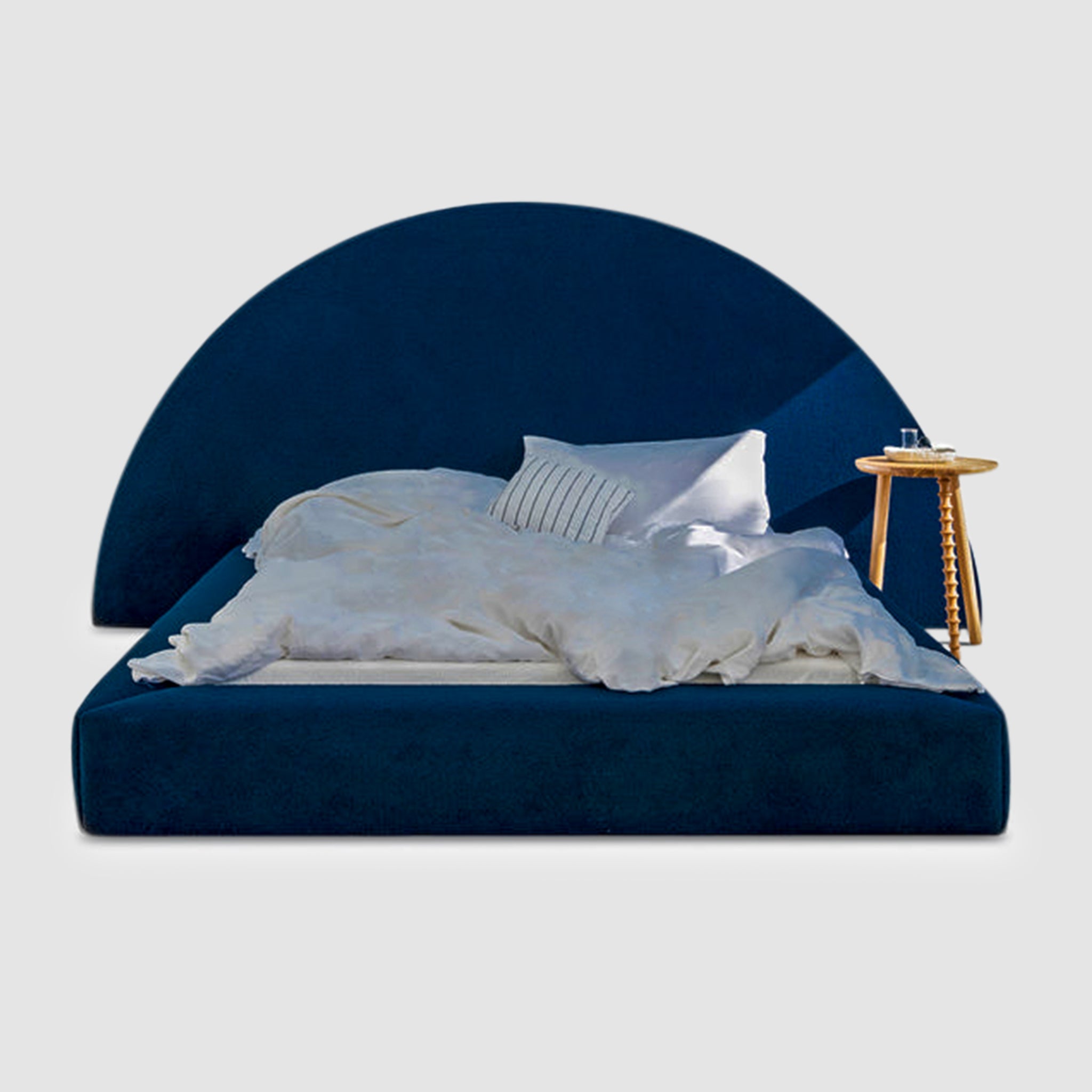 Blue upholstered bed with a large semi-circular headboard and a low profile frame. This luxurious bed is perfect for adding a touch of style and sophistication to any bedroom.