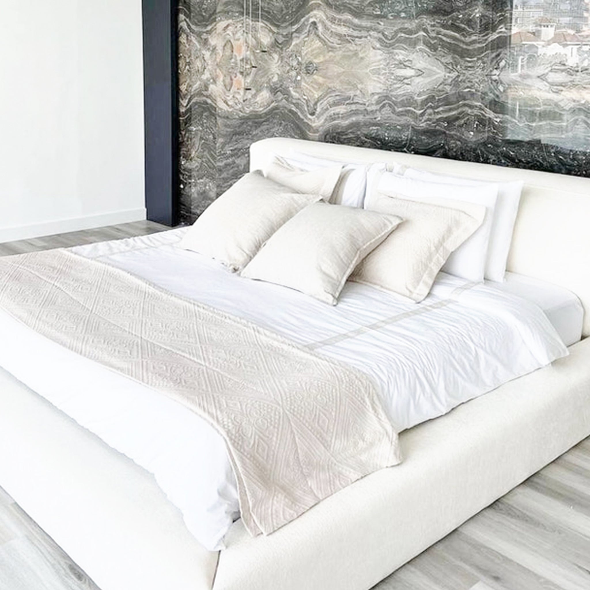 Luxurious white platform bed with plush headboard for ultimate relaxation. The Jerry Bed is perfect for comfortable mornings and restful sleep.