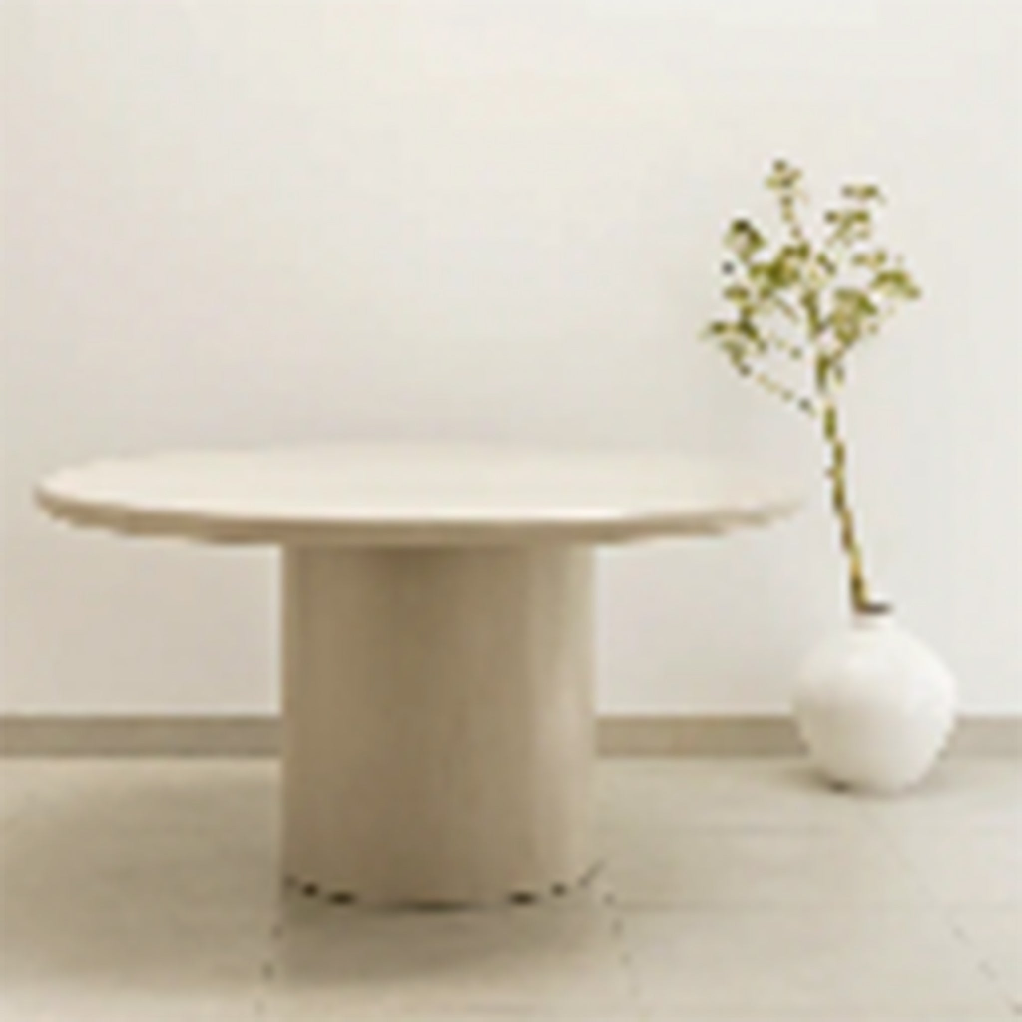 Elegant round dining table featuring a smooth, beige finish