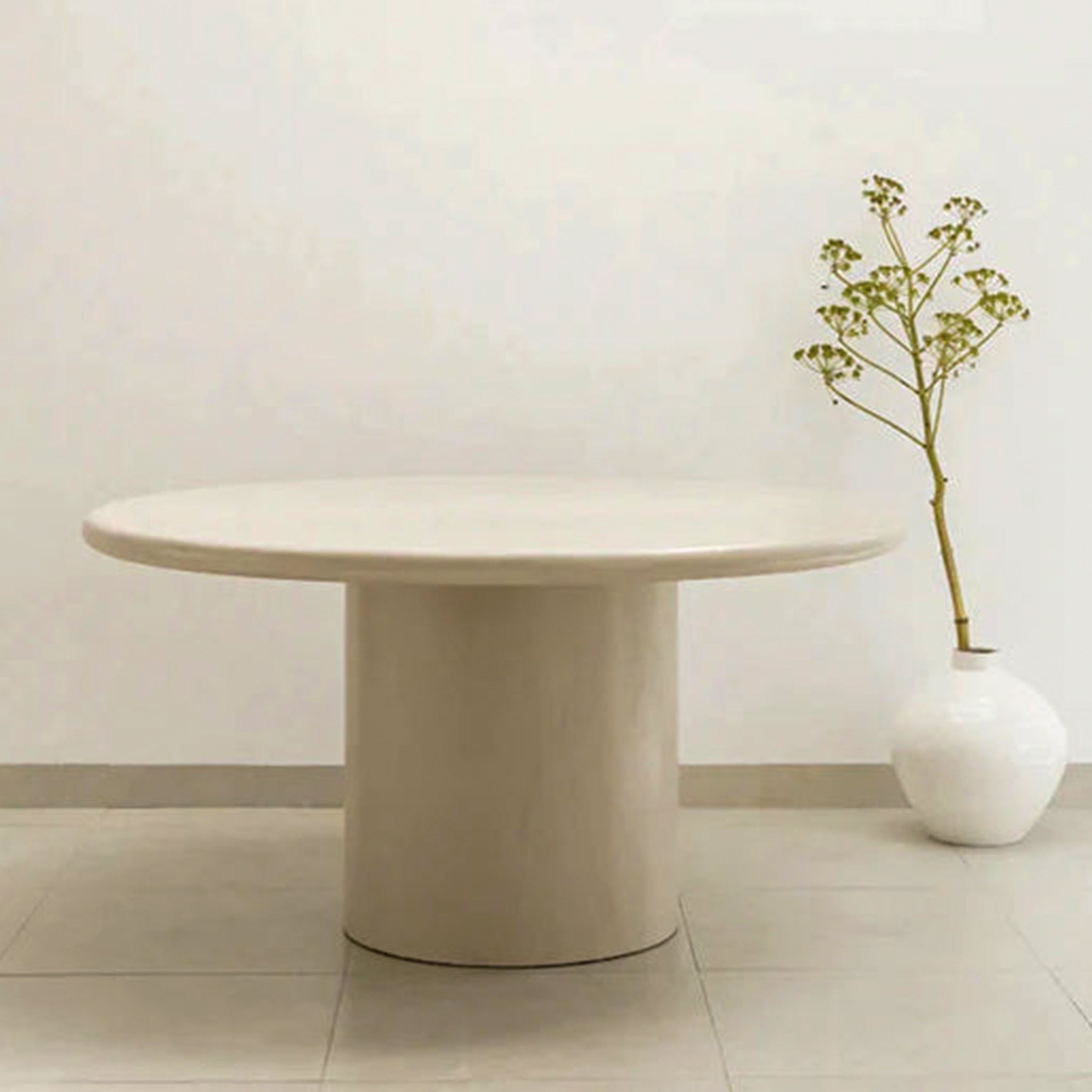 Modern beige dining table with a sleek, round design