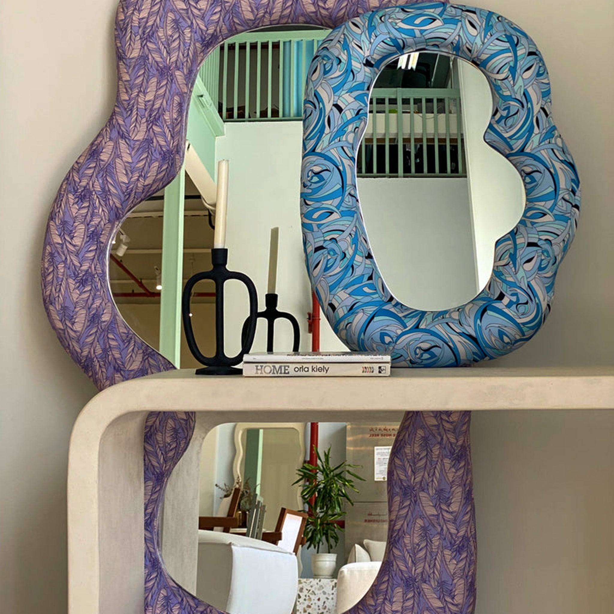 Wall-mounted mirror with a window reflected in its clean surface.