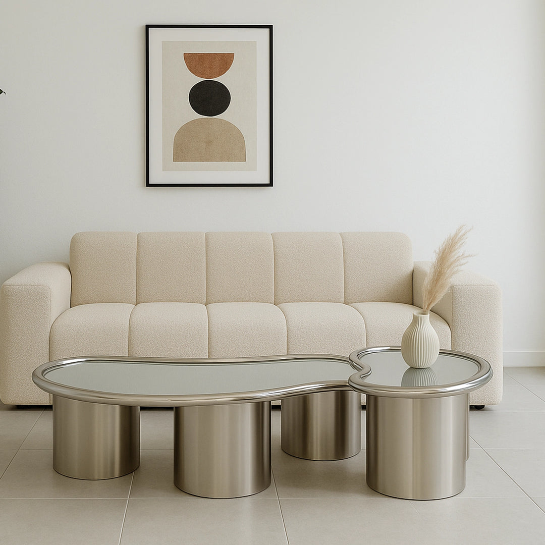 In a stylish living room setting, The Willow Chrome Coffee Table With Small Gestures serves as a functional and aesthetic centerpiece