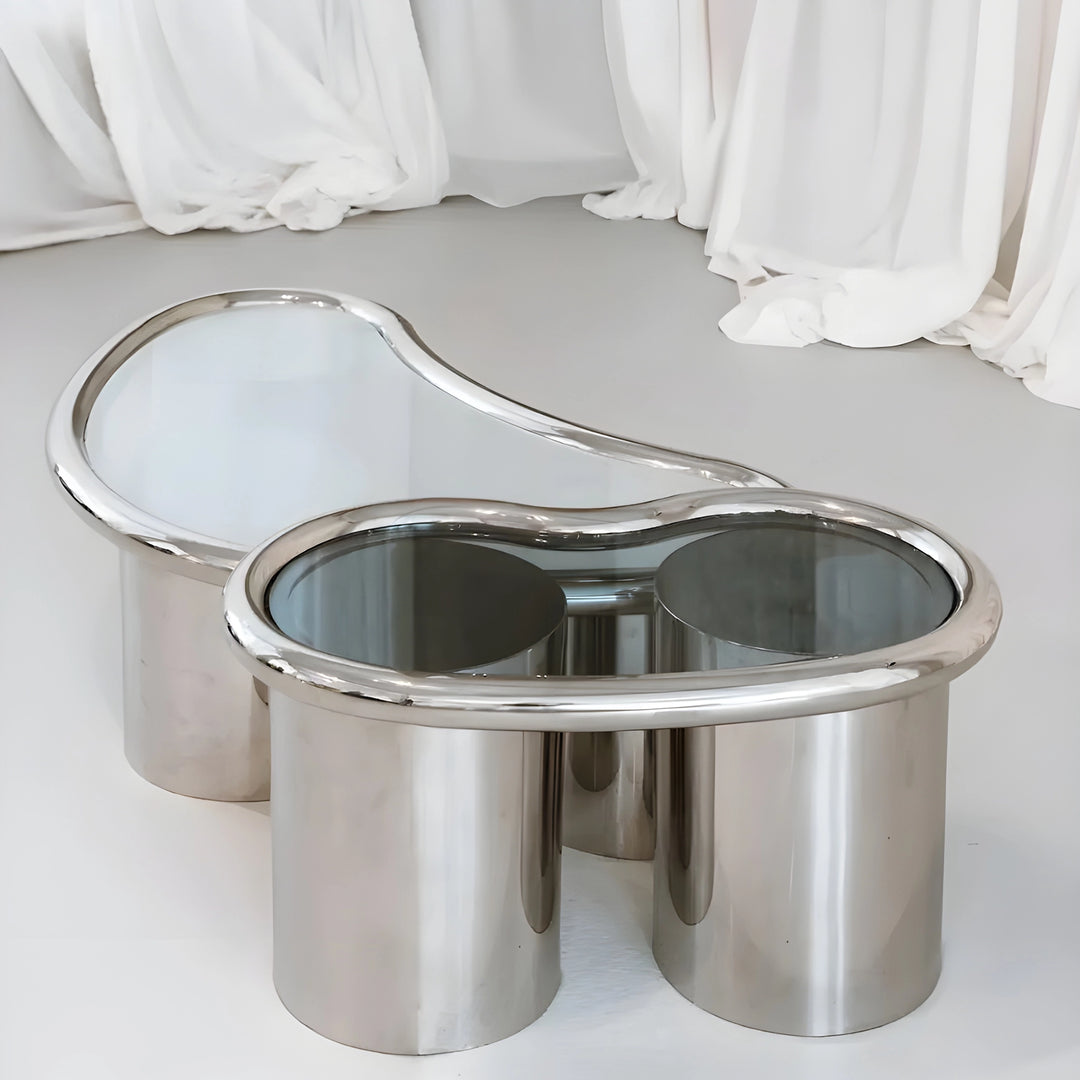 Close-up of The Willow Chrome Coffee Table With Small Gestures showcases its polished chrome legs and clear glass top.