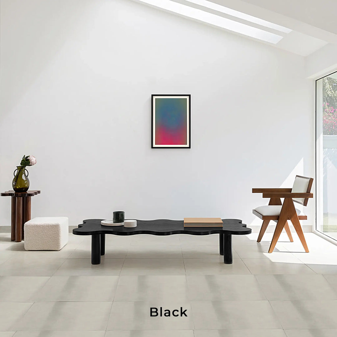 Lifestyle image featuring The Edith Curvy Wood Coffee Table in black, set in a modern living room.