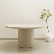 The Marx Microplaster round dining table styled in a contemporary dining room, offering both elegance and function.
